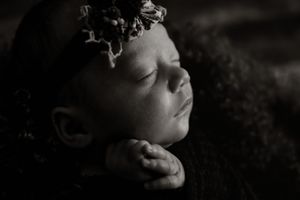 Dramatic black and white portrait with moody lighting and shadows.