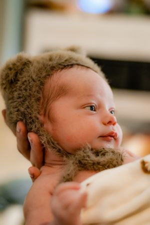 Series of close-up shots showing baby wearing fuzzy animal hat looking to the side.