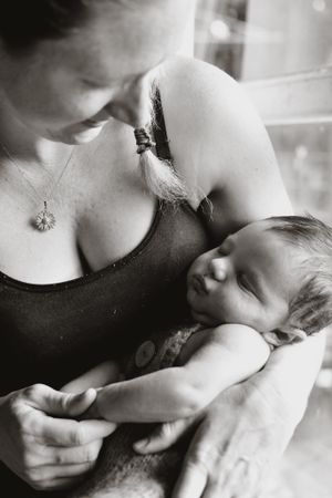 Black and white intimate maternity portrait in soft, natural lighting.