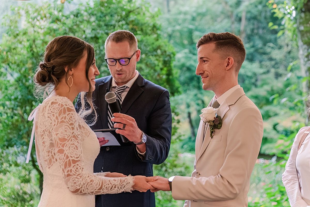 Bride and groom holding hands during wedding ceremony captured by Indianapolis wedding photographer