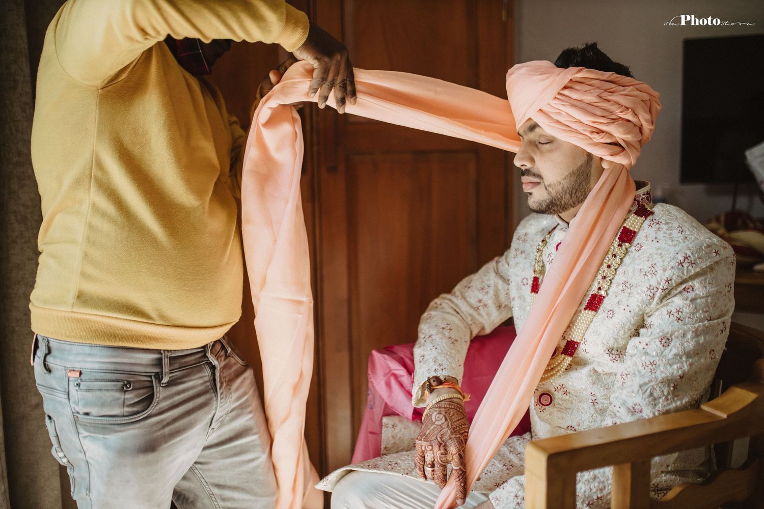Traditional Indian wedding preparation with pink and white floral decorations and elegant attire.