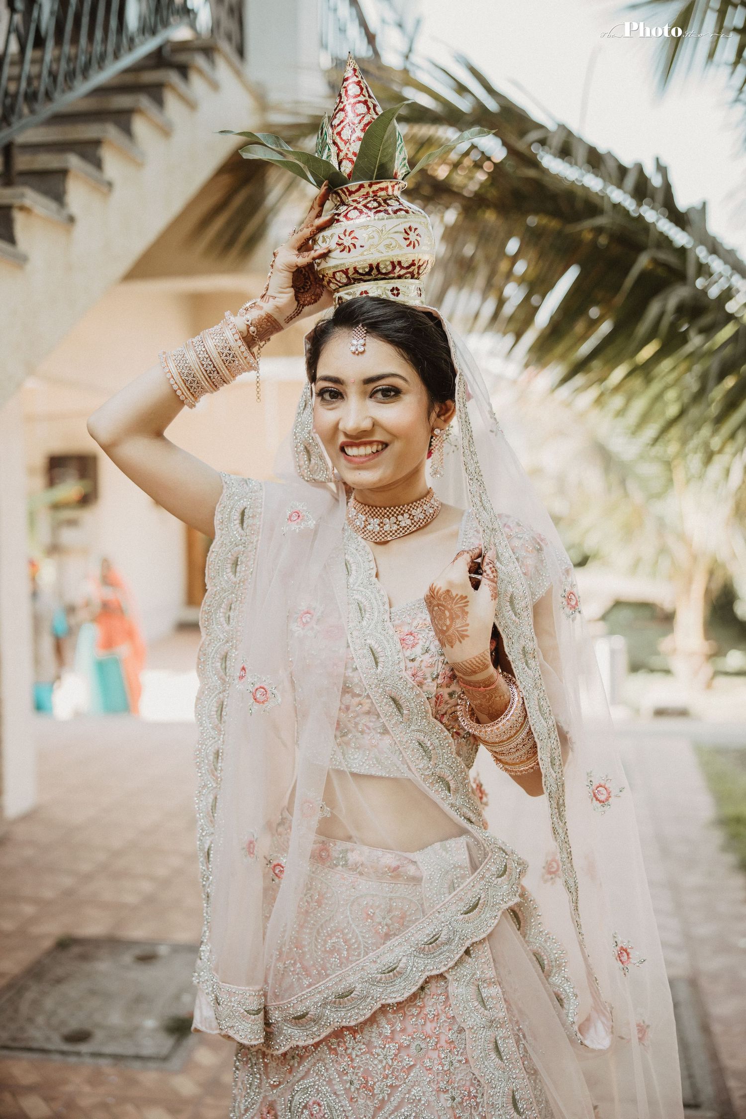Elegant bridal portrait in white and pink embroidered traditional Indian wedding attire with delicate veil.