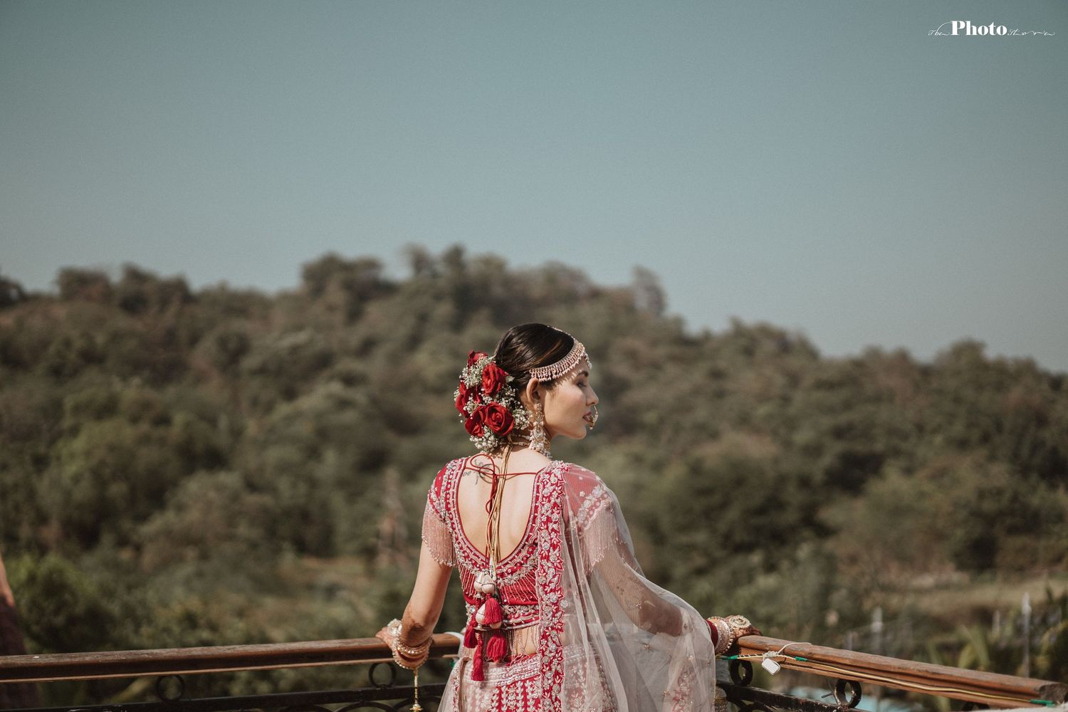 Outdoor wedding photography session against natural landscape with flowing fabric and traditional attire.