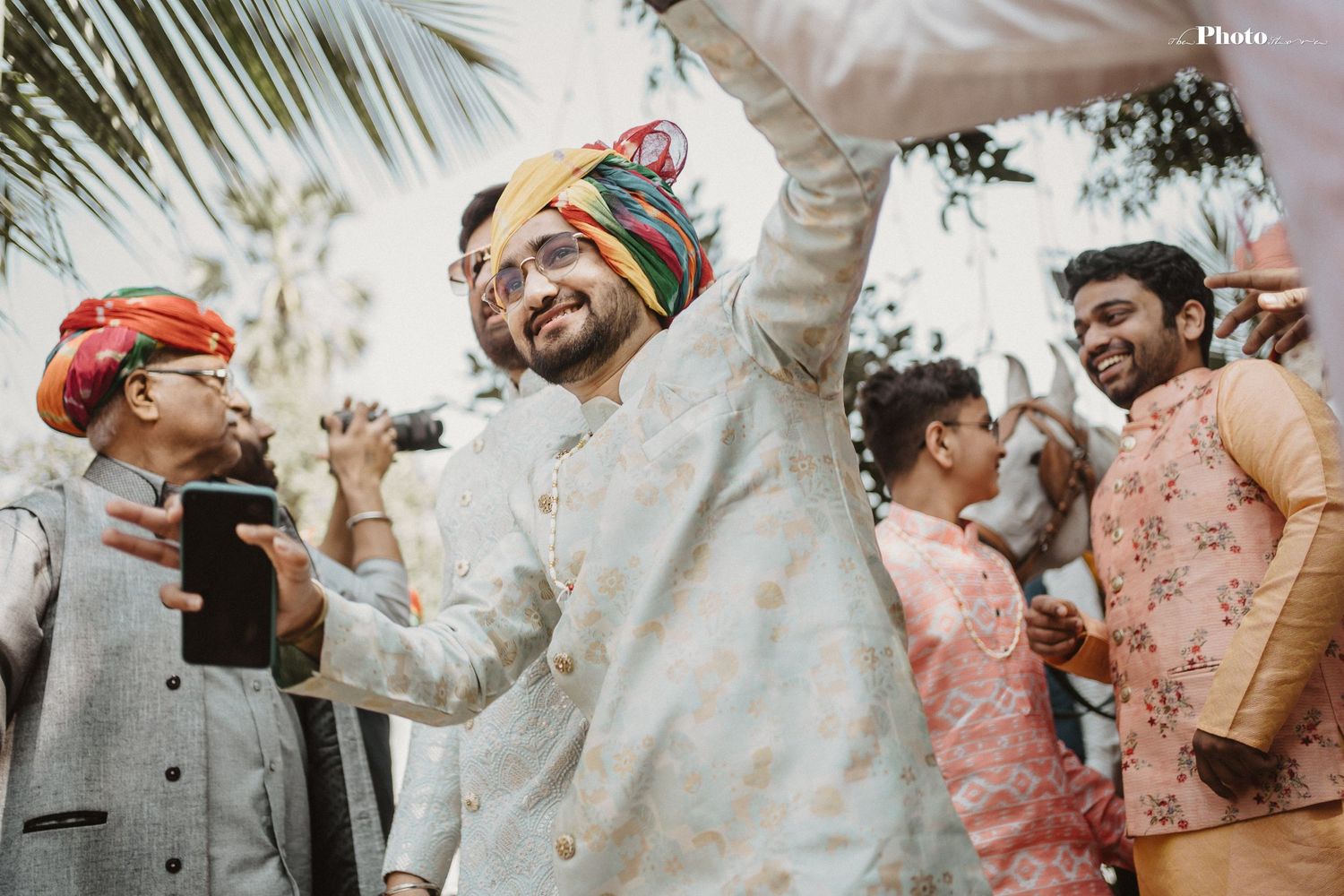 Celebratory group in traditional attire dancing and enjoying festivities outdoors.
