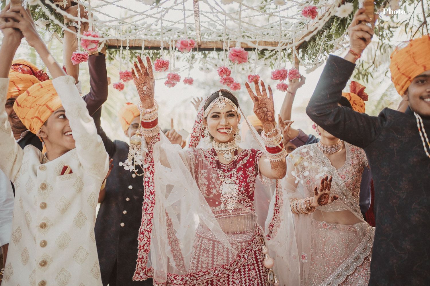 Joyous celebration with flower petals being tossed during outdoor wedding ceremony.