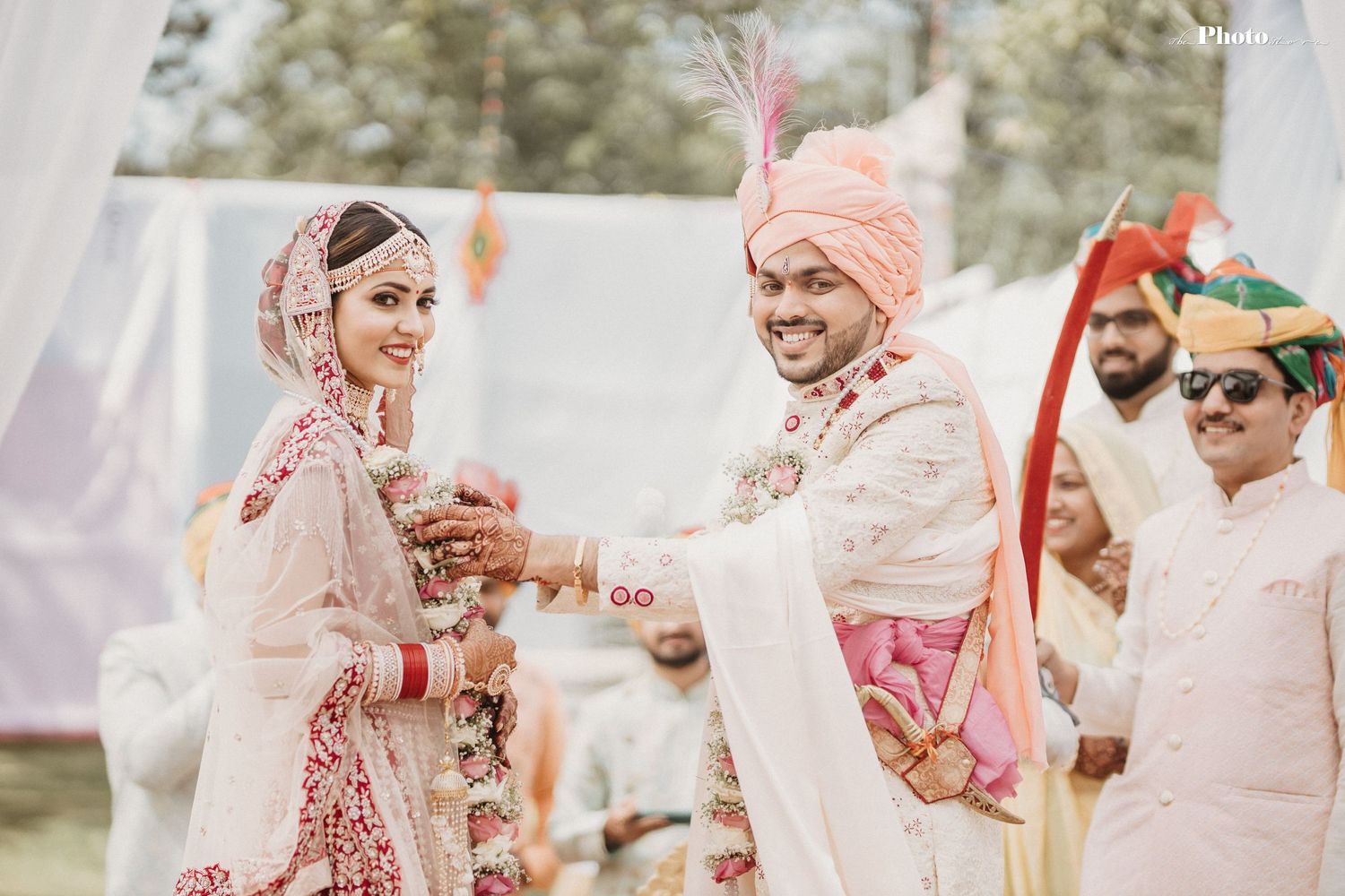 Candid moment during Indian wedding ceremony with traditional outfits and decor.