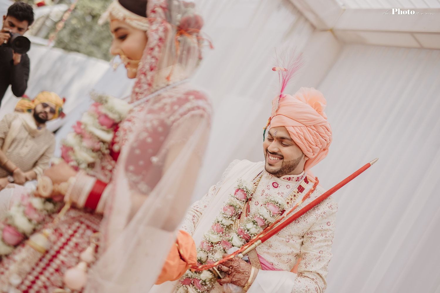 Joyful moments captured during an outdoor Indian wedding ceremony with pink and white decor.