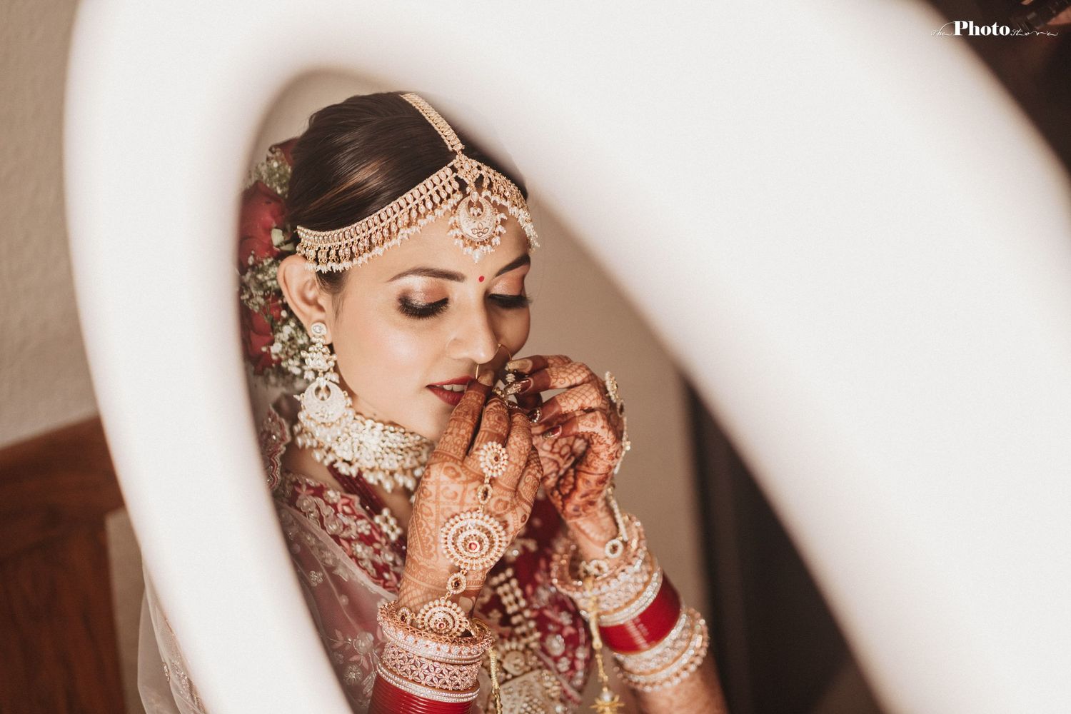 Artistic framed shot of Indian bridal details with henna decorated hands and traditional jewelry.