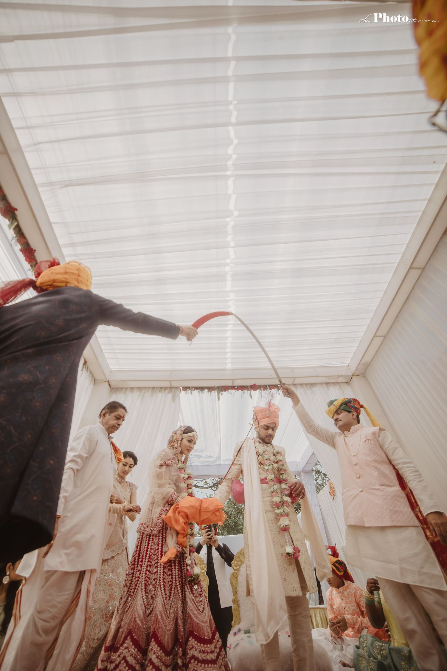 Traditional Hindu wedding ceremony under white tent with guests in attendance.