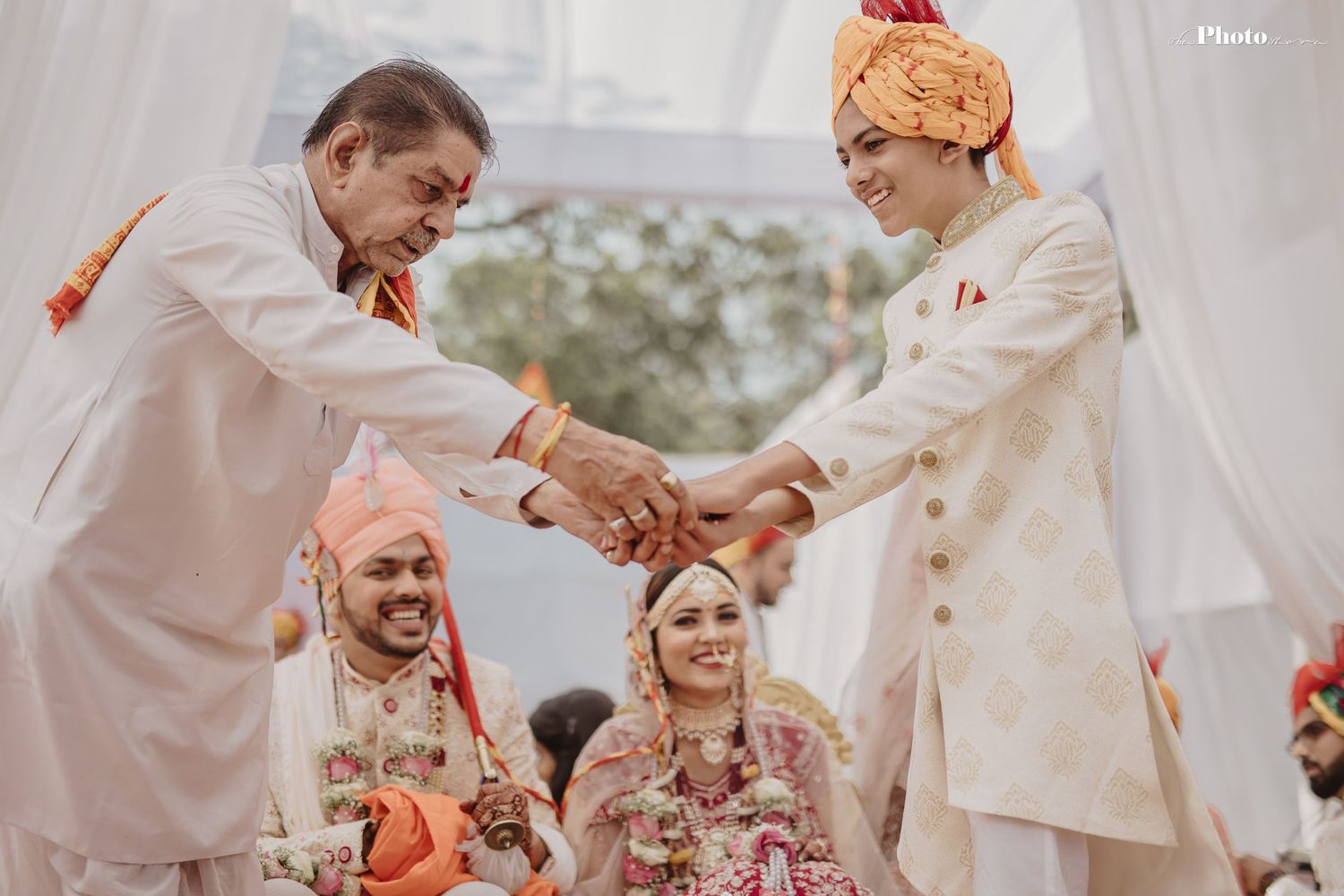 Traditional Indian wedding ceremony with joyful rituals and colorful decorations under a white mandap.
