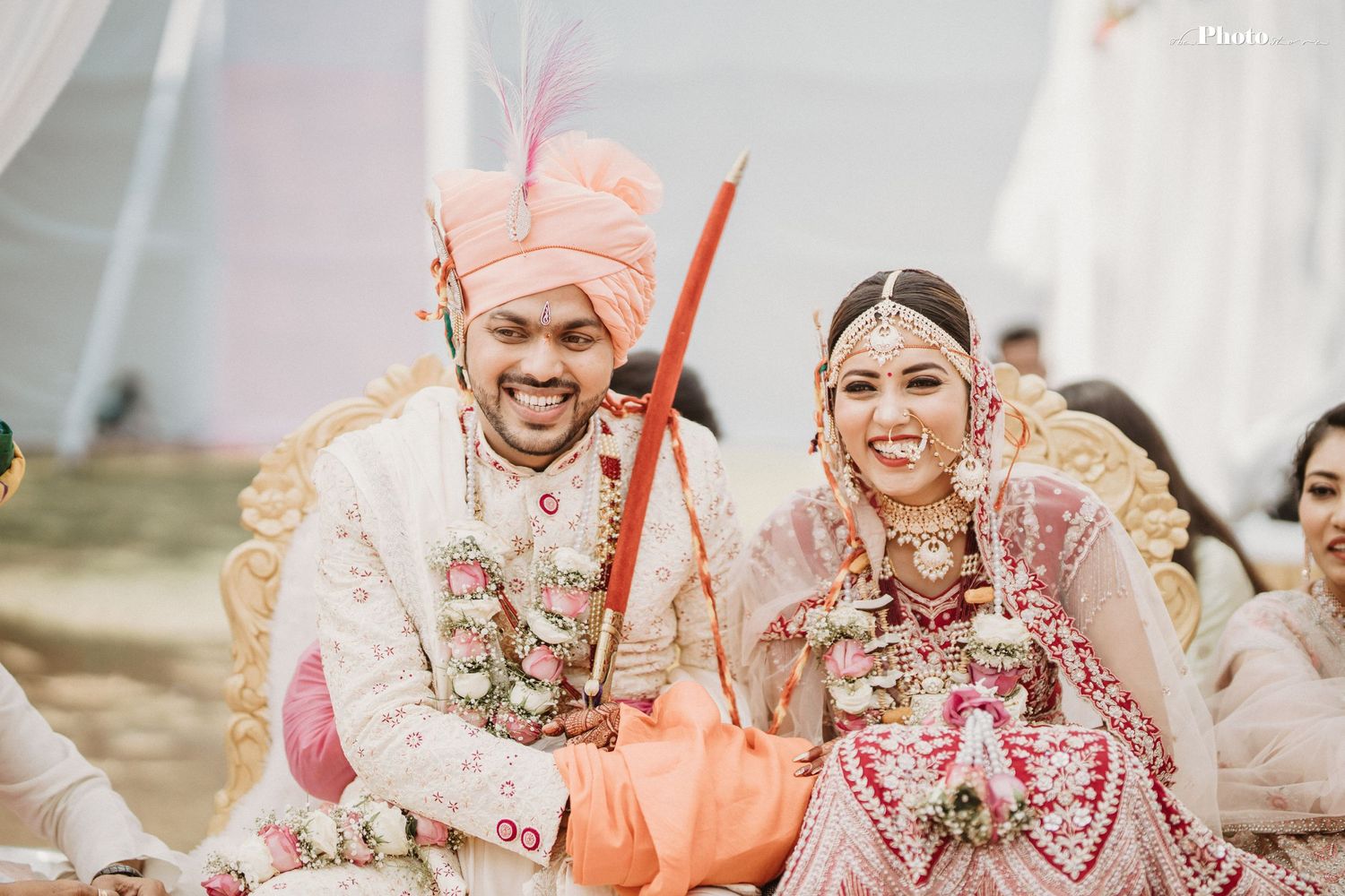 Festive Indian wedding ceremony with participants in traditional attire performing cultural rituals.
