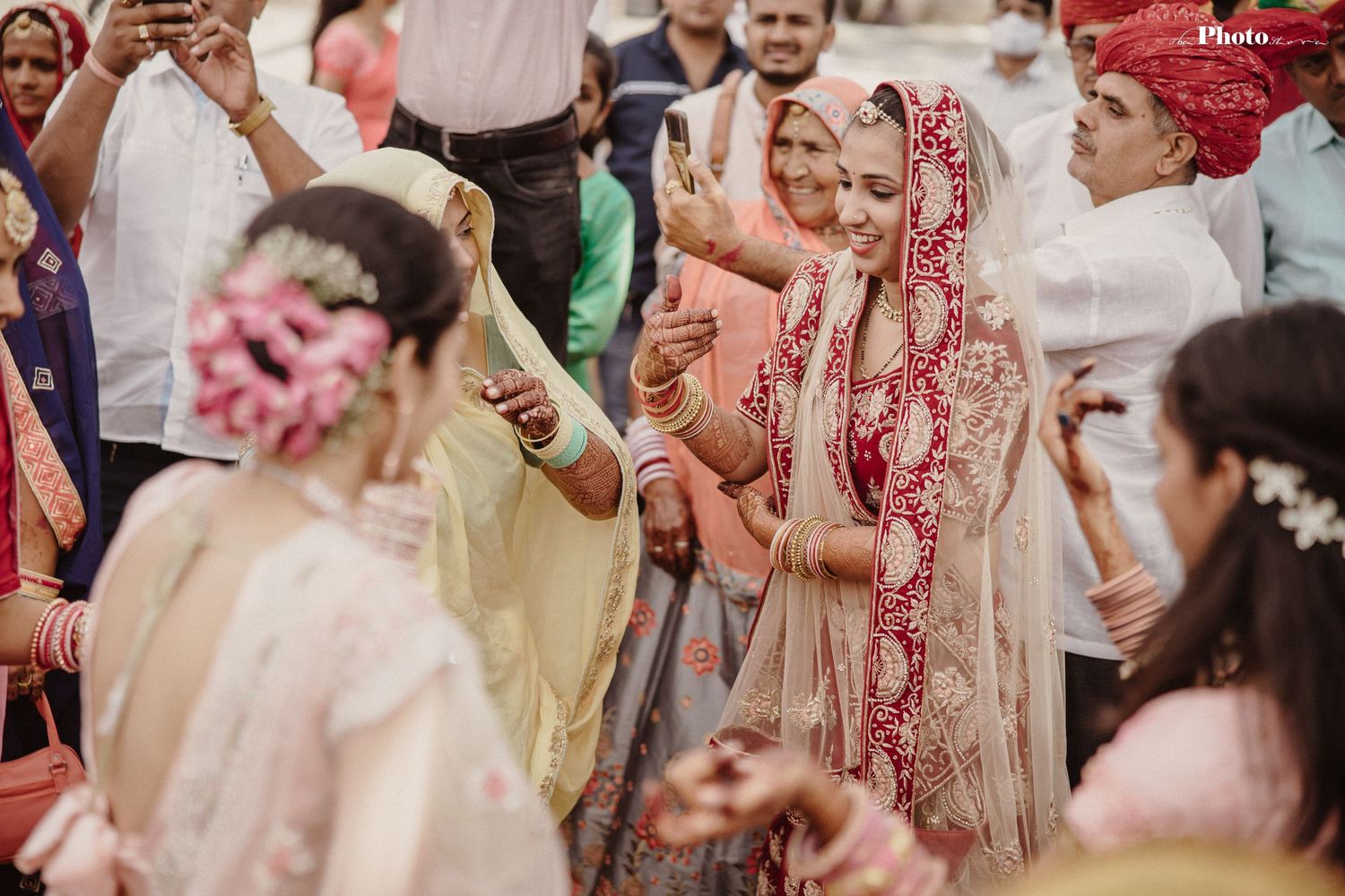 Guests celebrate at a vibrant outdoor Indian wedding ceremony with colorful traditional attire and decor.