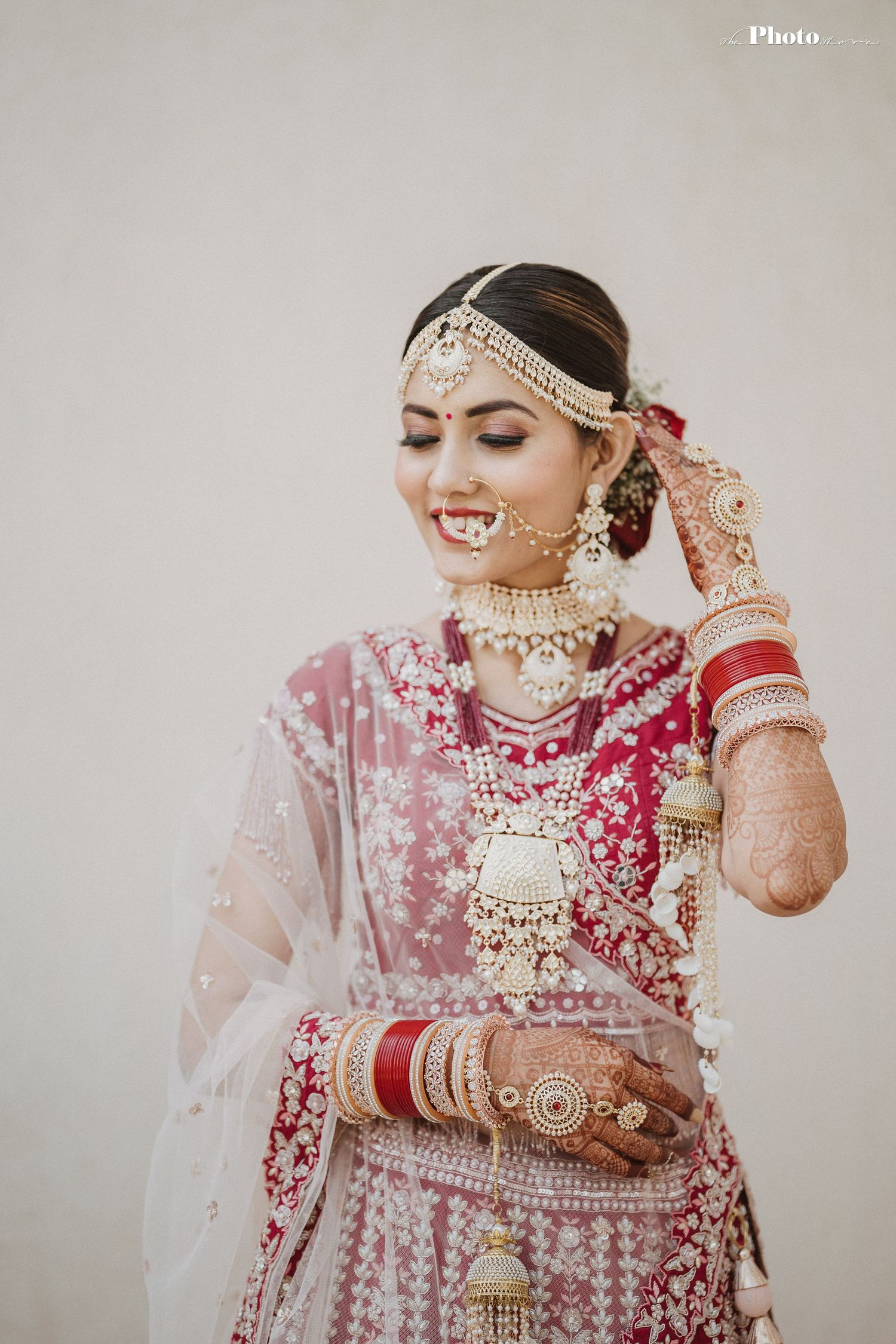Close-up details of intricate bridal jewelry and embroidered wedding attire in red and gold.