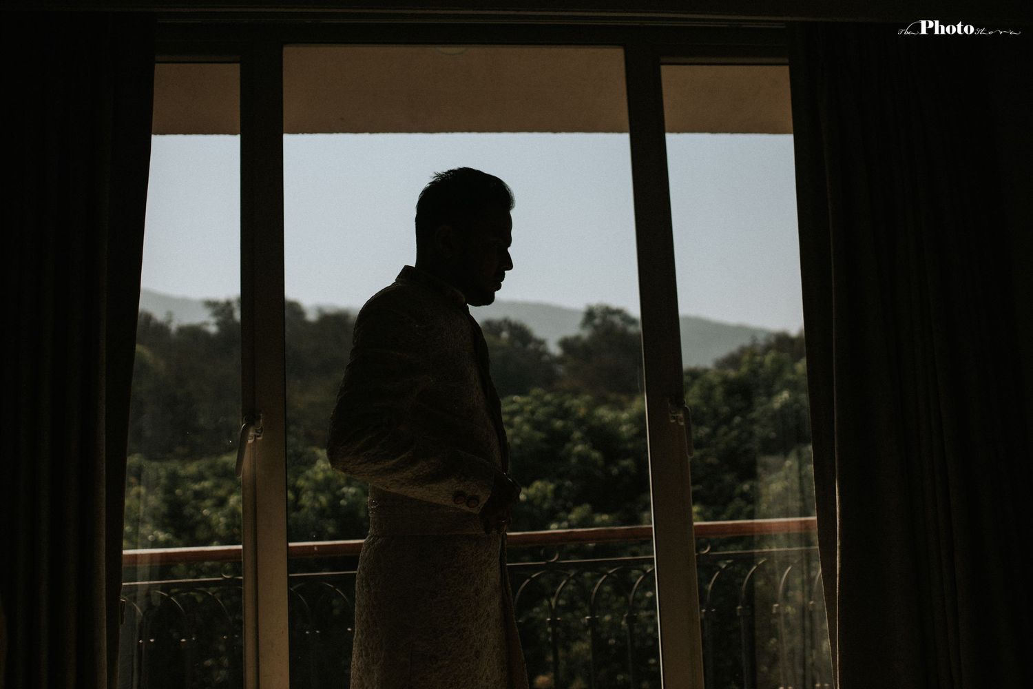 Silhouetted figures against large windows during golden hour.