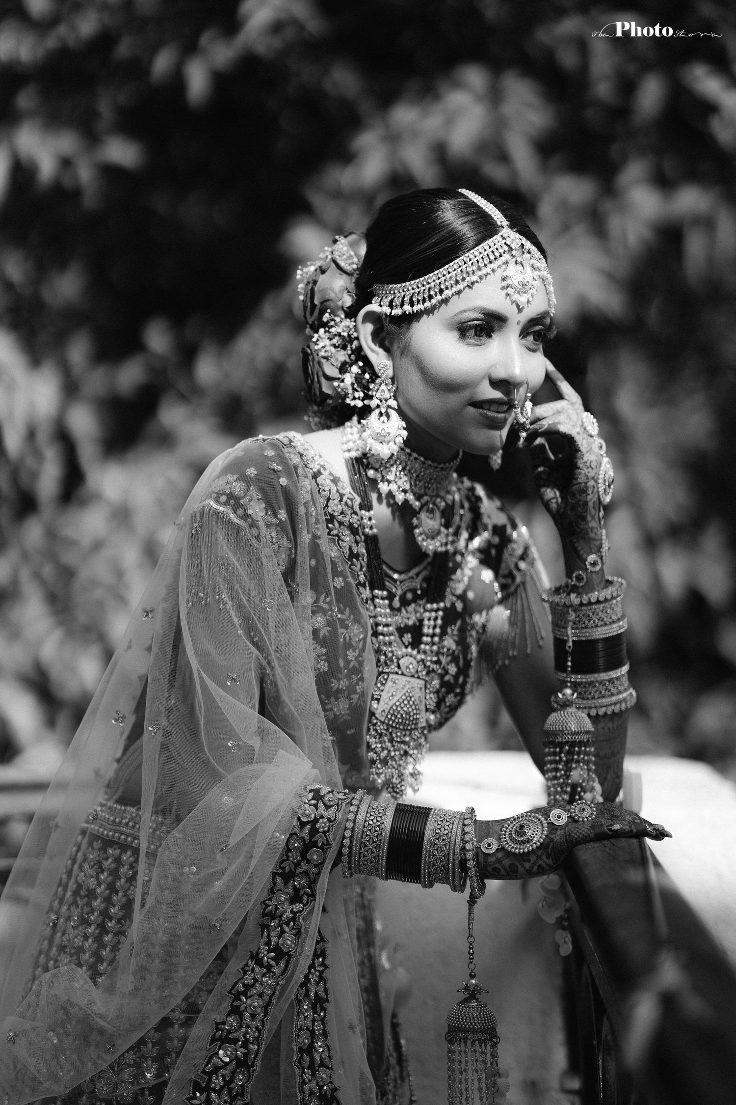 Black and white artistic portrait showcasing traditional Indian bridal jewelry and attire.
