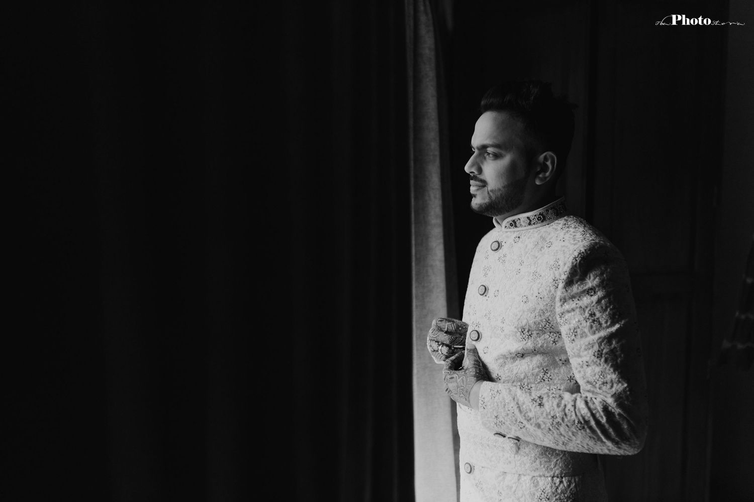 Dramatic black and white portrait in front of window with soft natural lighting.