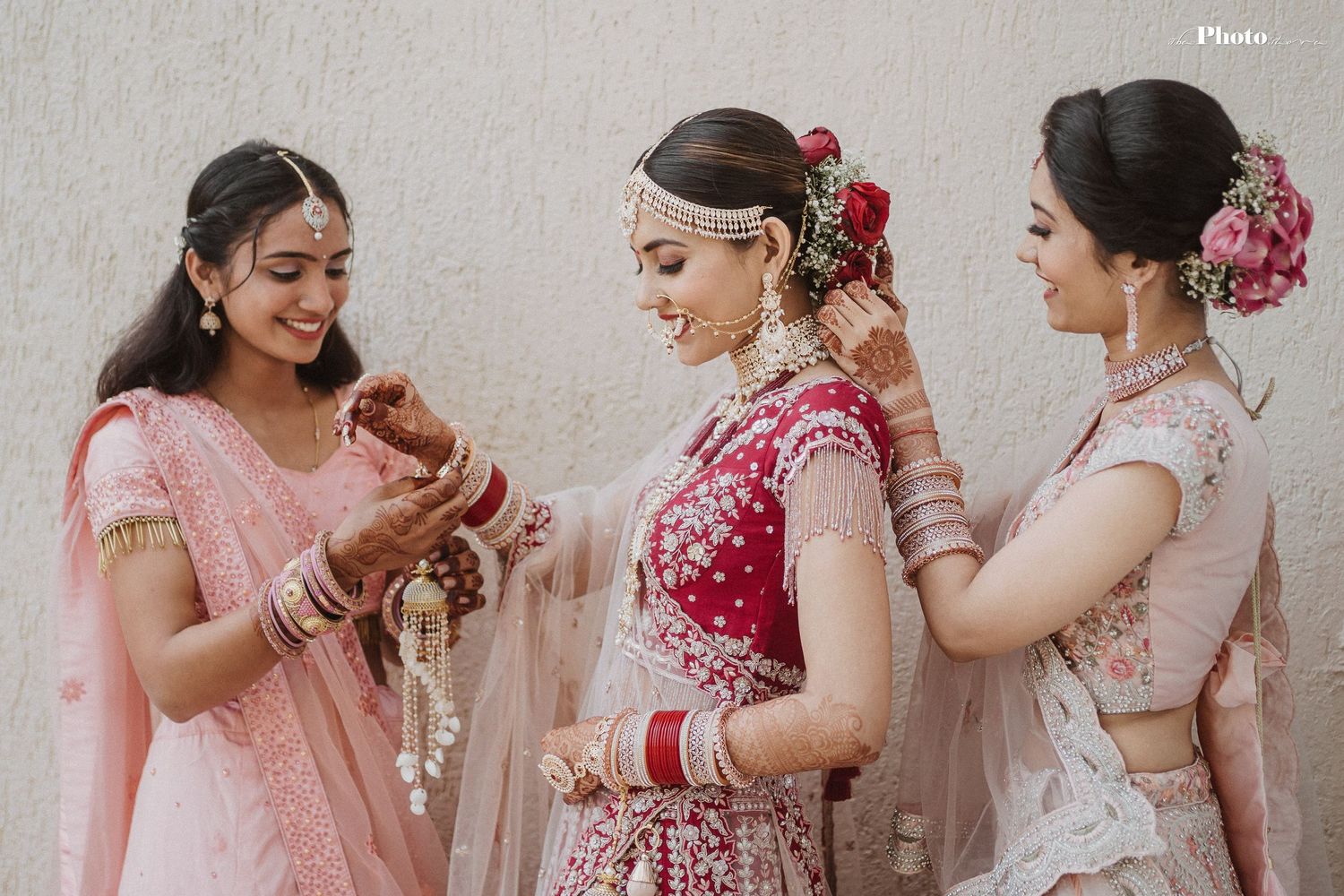 Group wearing pink and red traditional outfits during celebration preparations.
