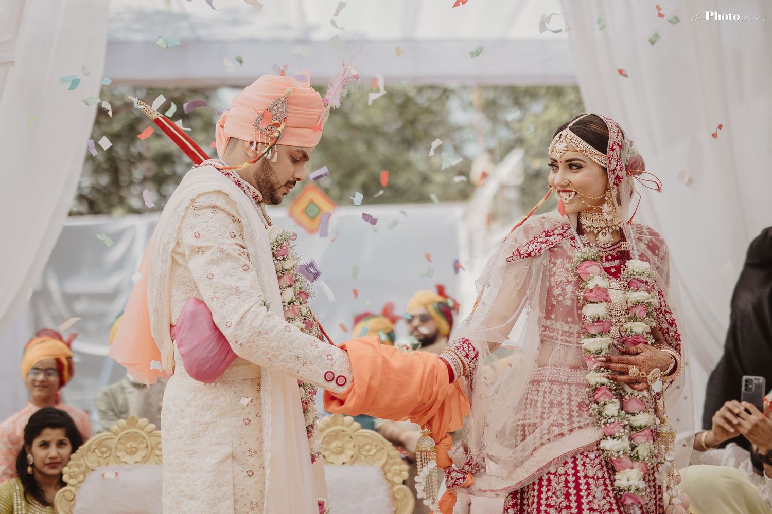 Festive Indian wedding celebration with rose petals and traditional decorations.