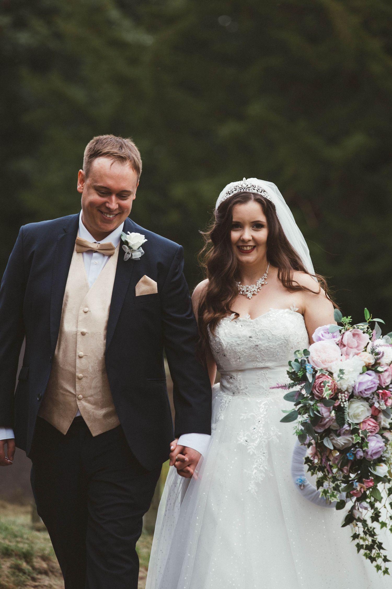 Bride and groom share candid moments together during their outdoor wedding photoshoot.