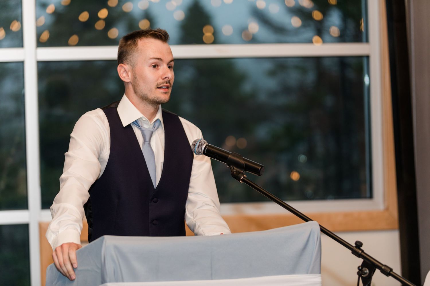 Wedding celebration speeches being delivered during evening reception.