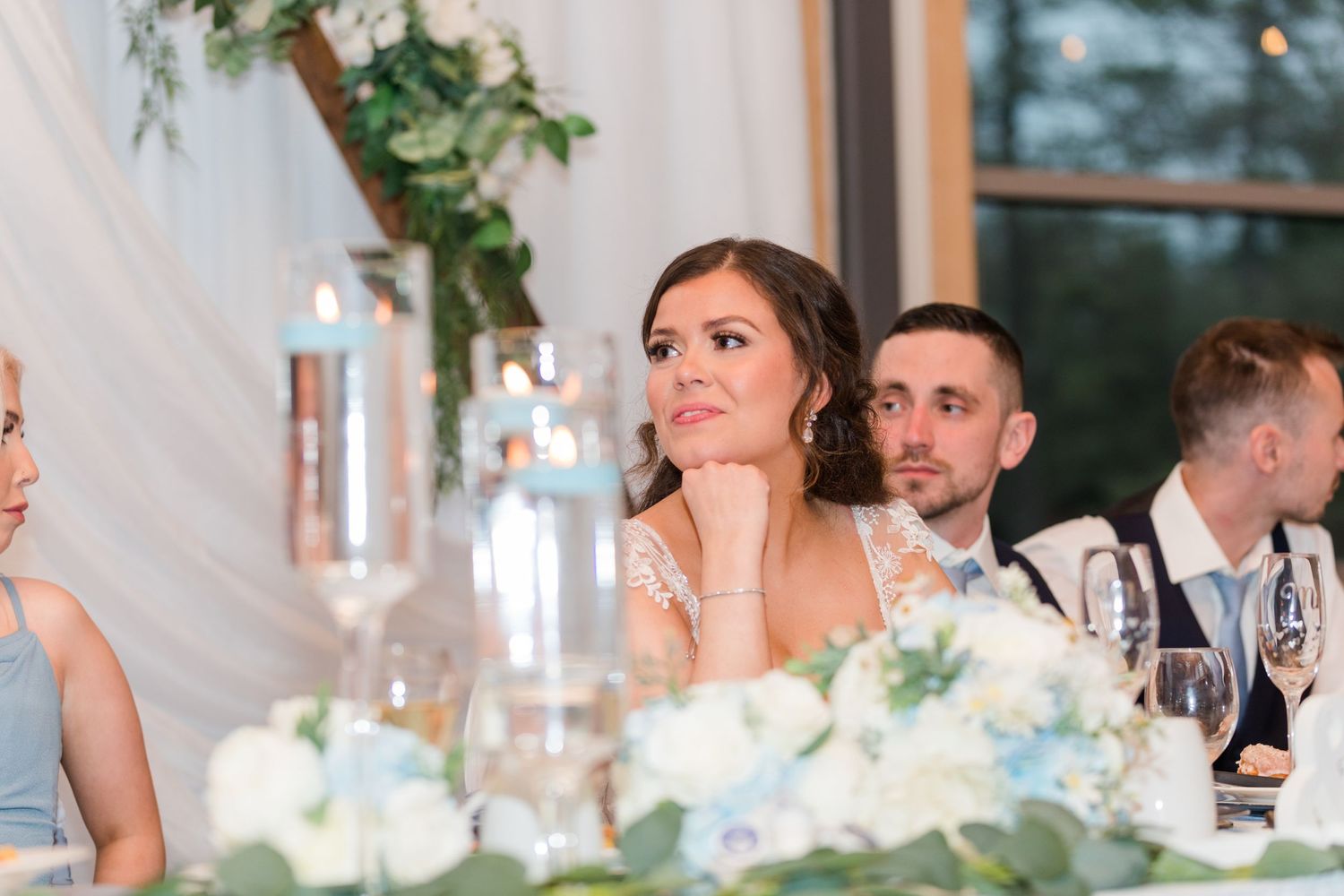 Wedding guests enjoying dinner and speeches during reception celebration.