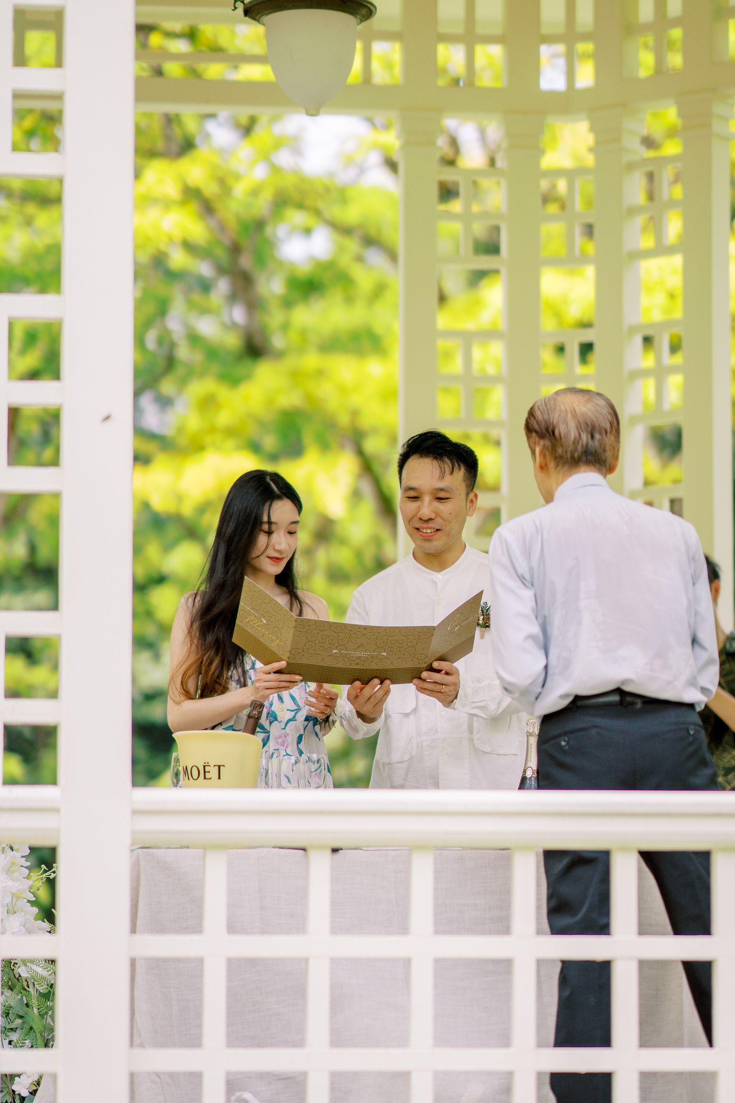 Guests enjoying conversation in an elegant white outdoor pavilion setting.