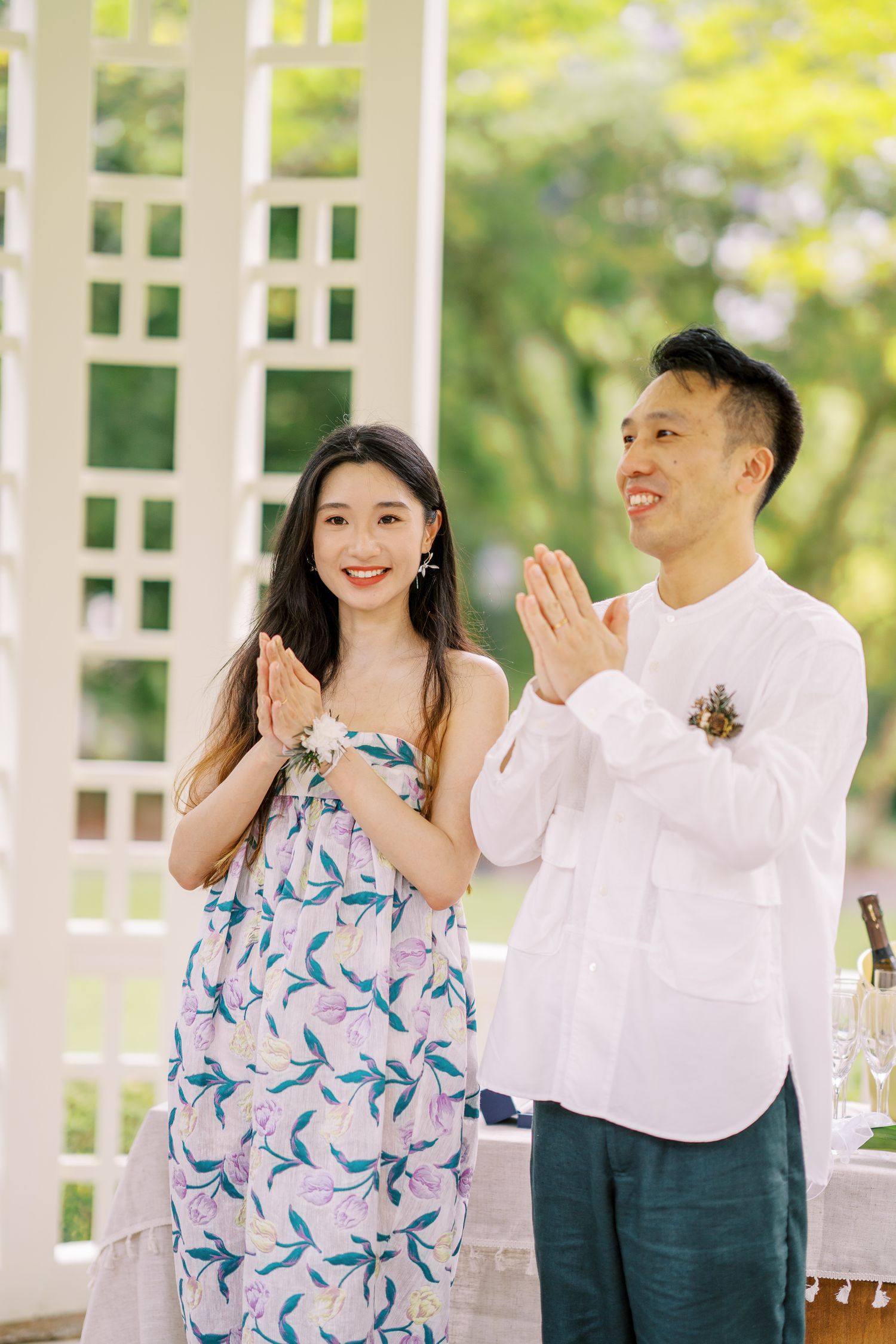People clapping and celebrating in a bright outdoor pavilion.