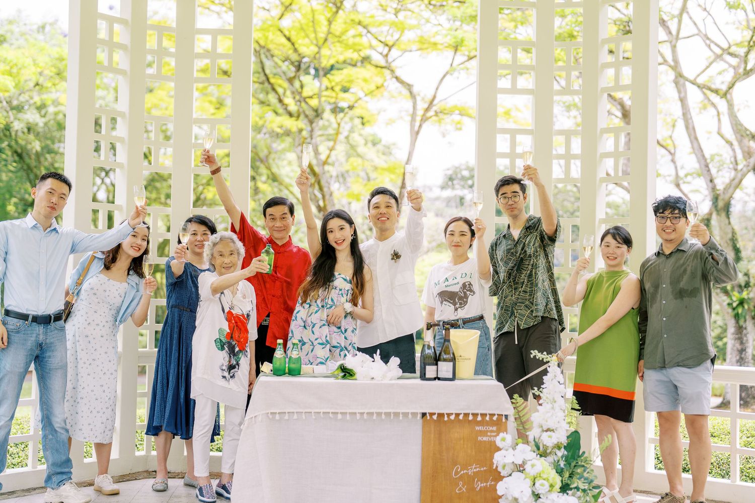Group celebration in an outdoor pavilion with guests raising glasses in toast.