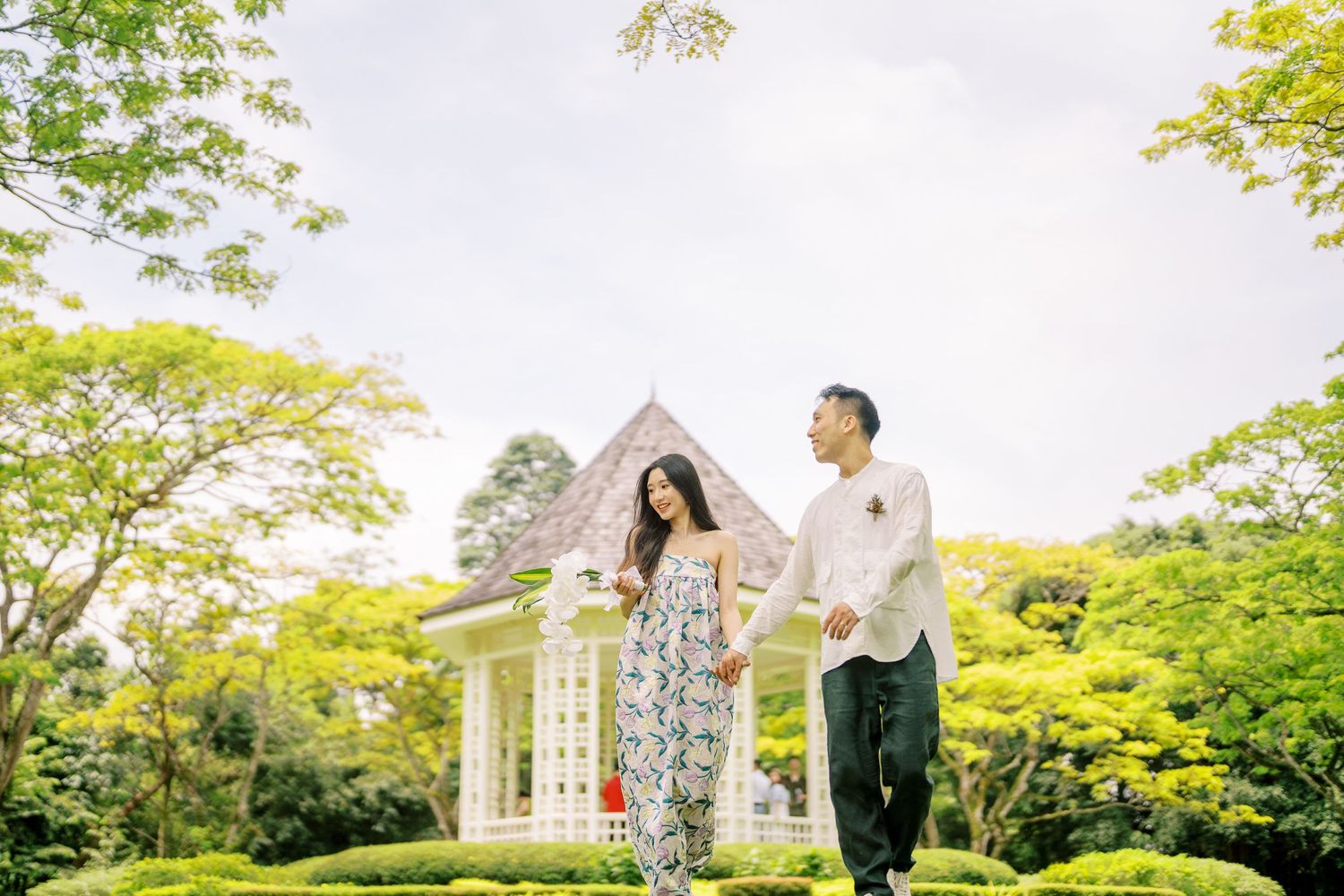 Garden celebration under a white gazebo with lush green trees in background.