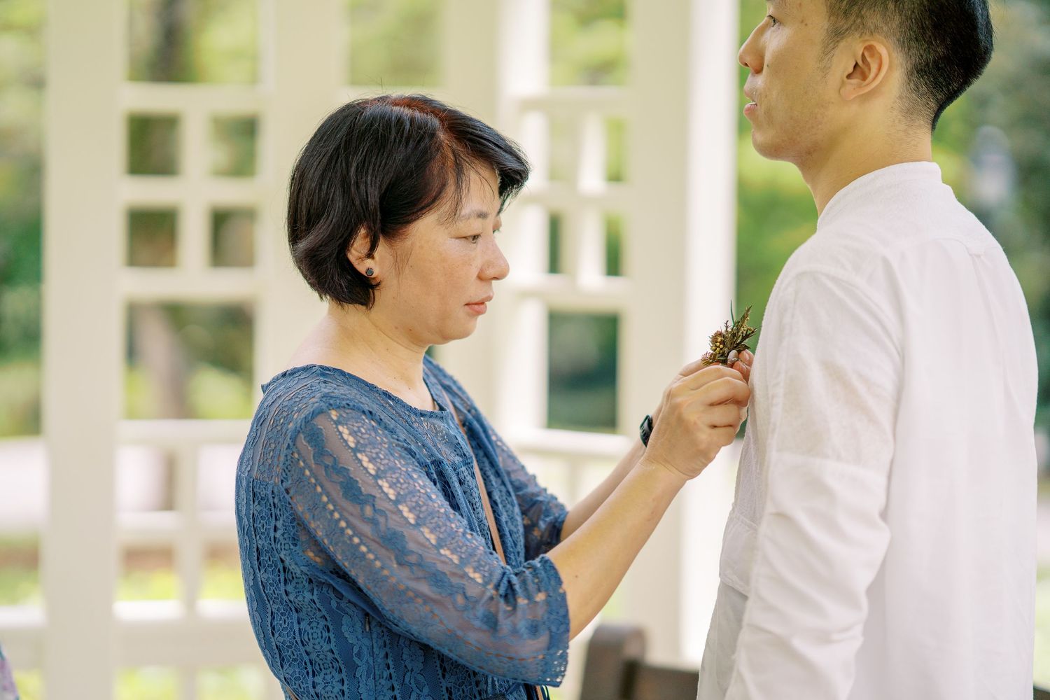 Two people sharing an intimate moment while pinning boutonniere.