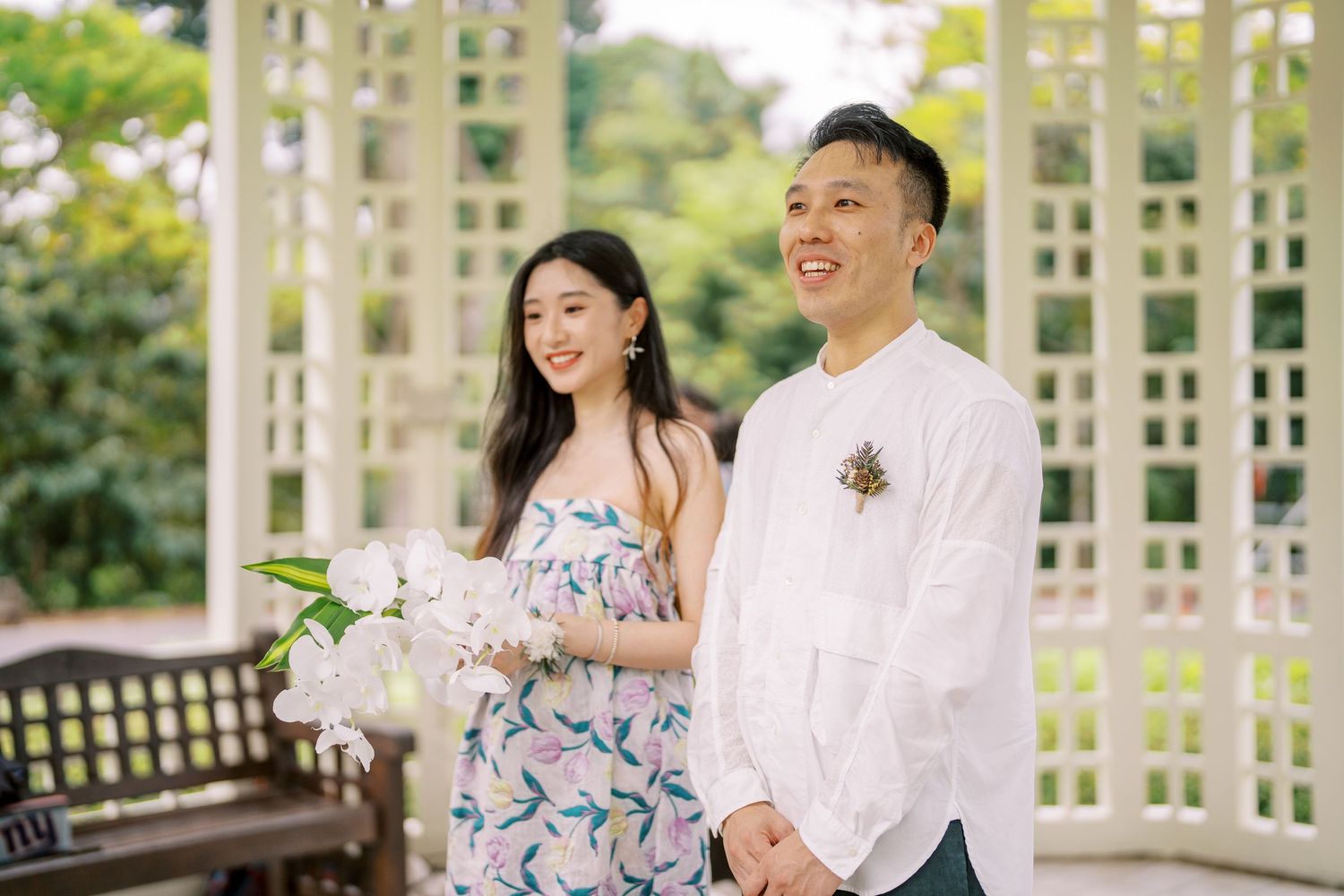 A joyful moment captured under a white pergola with decorative elements and natural lighting.