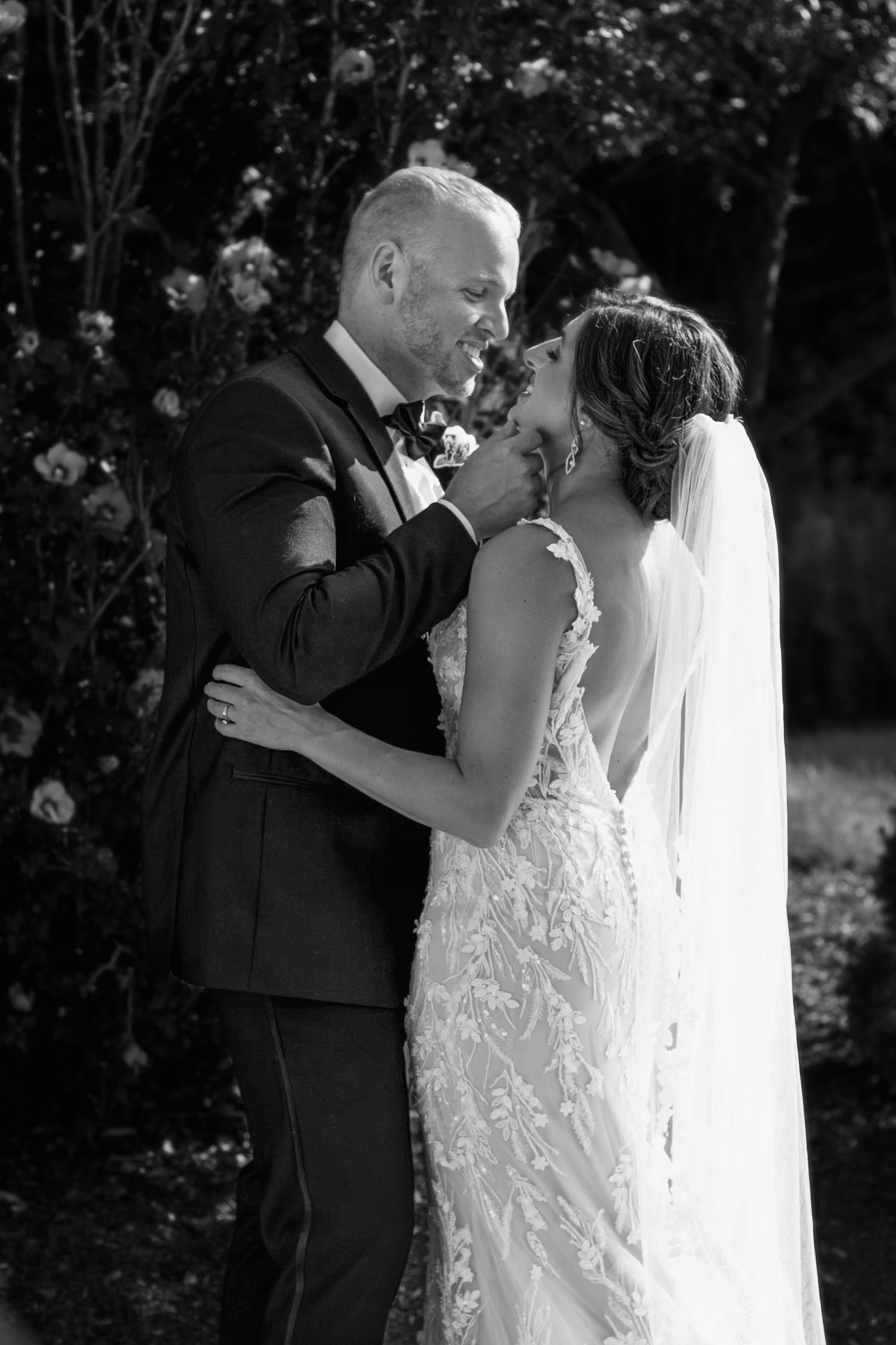 An intimate black and white portrait of newlyweds sharing a tender moment.