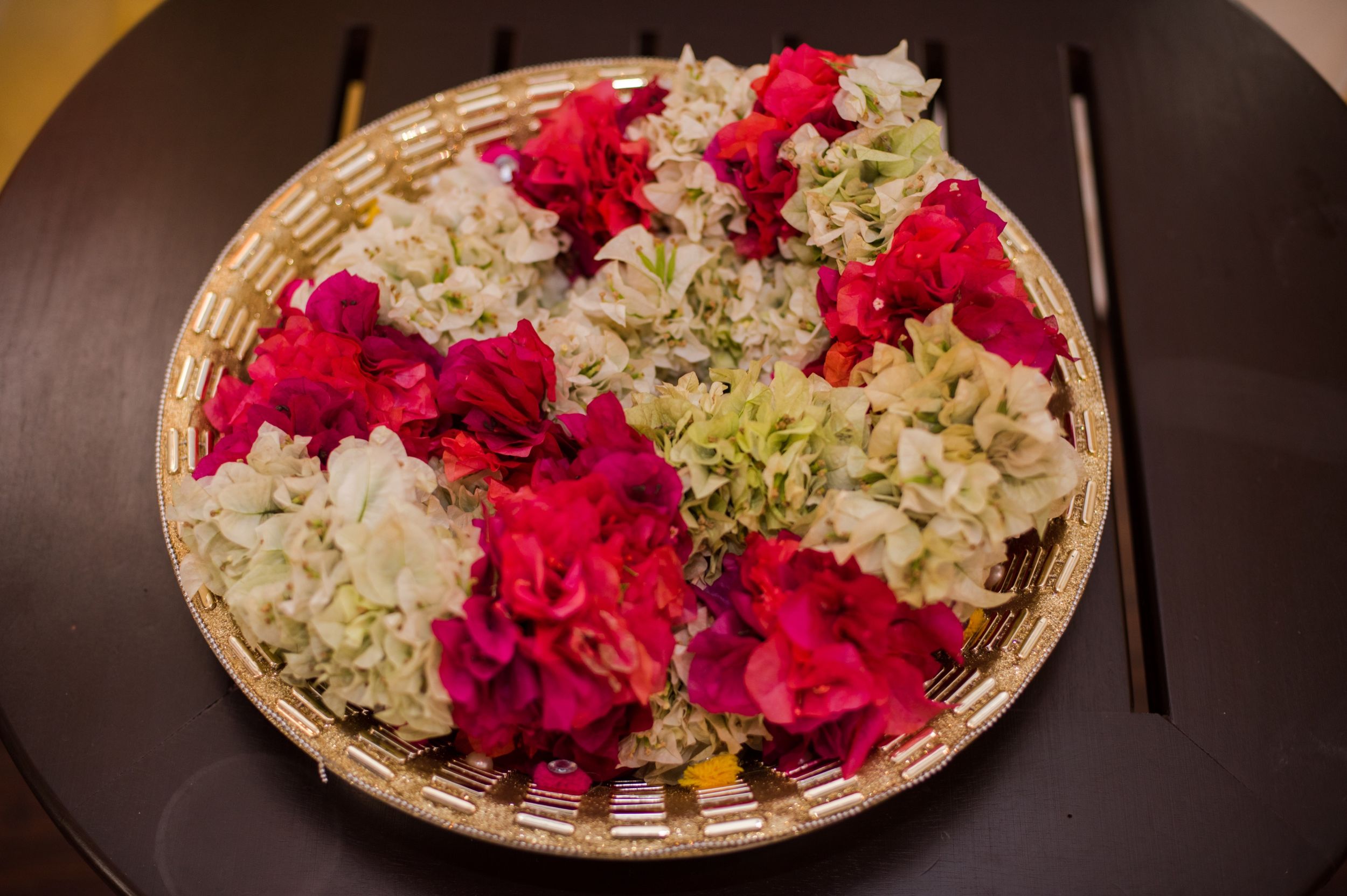 Decorative arrangement of pink roses and white hydrangeas in a woven basket.