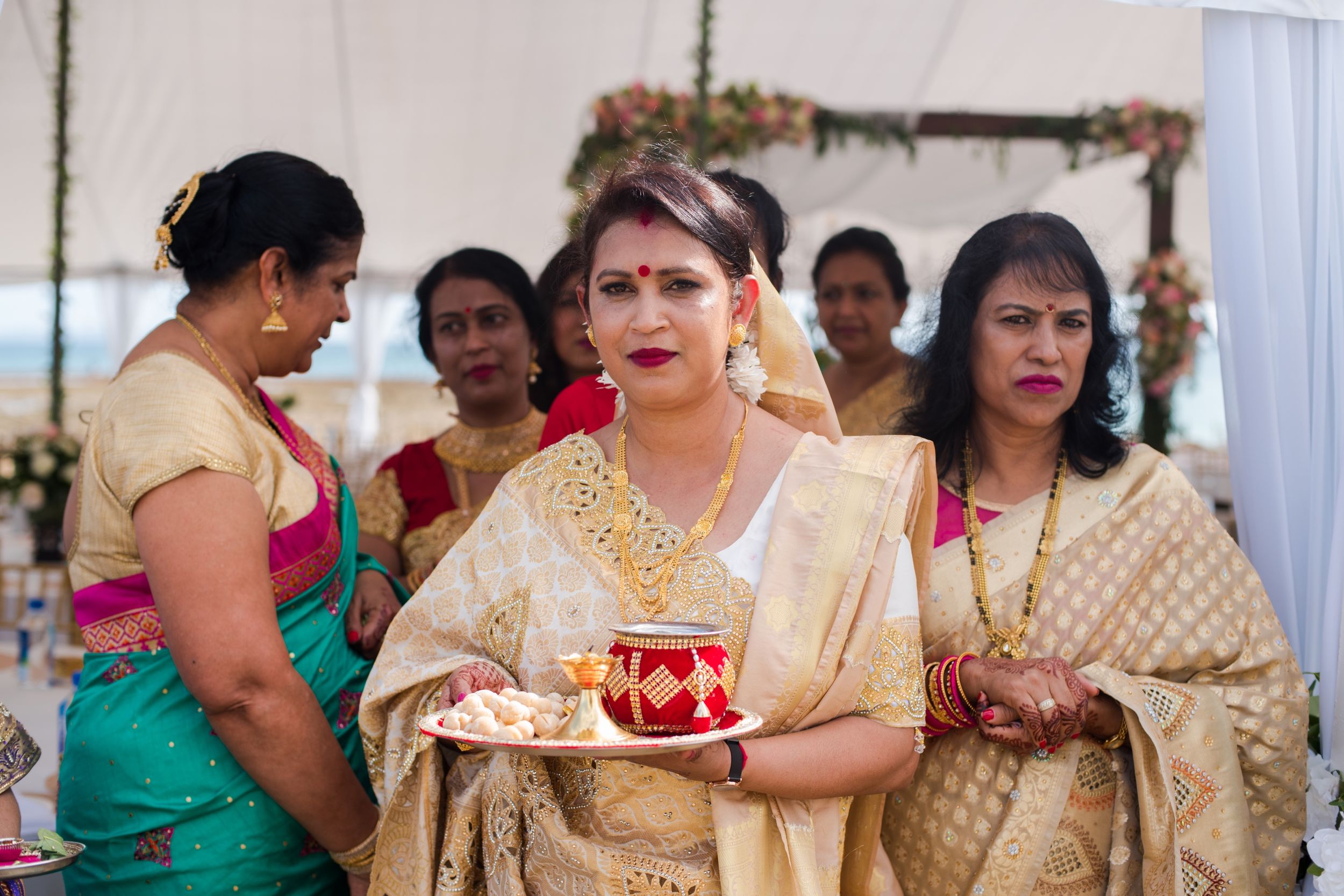 Traditional Indian wedding ceremony with guests in colorful saris and formal wear.