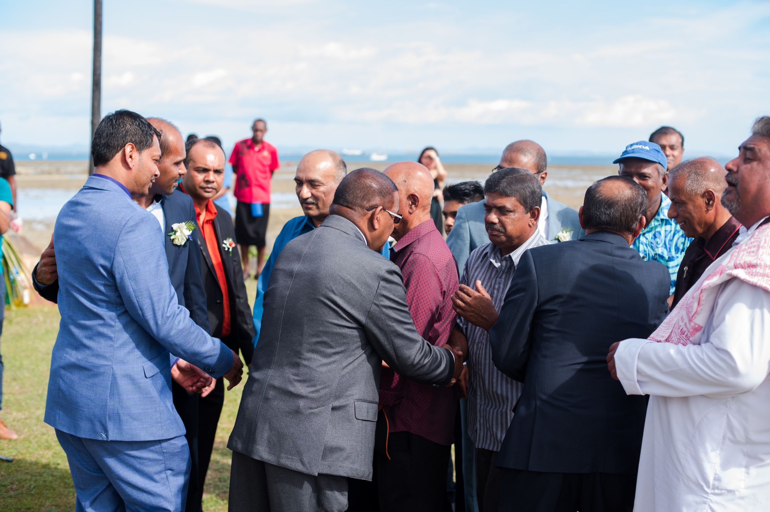 A group of formally dressed guests gathering outdoors during a celebration event.