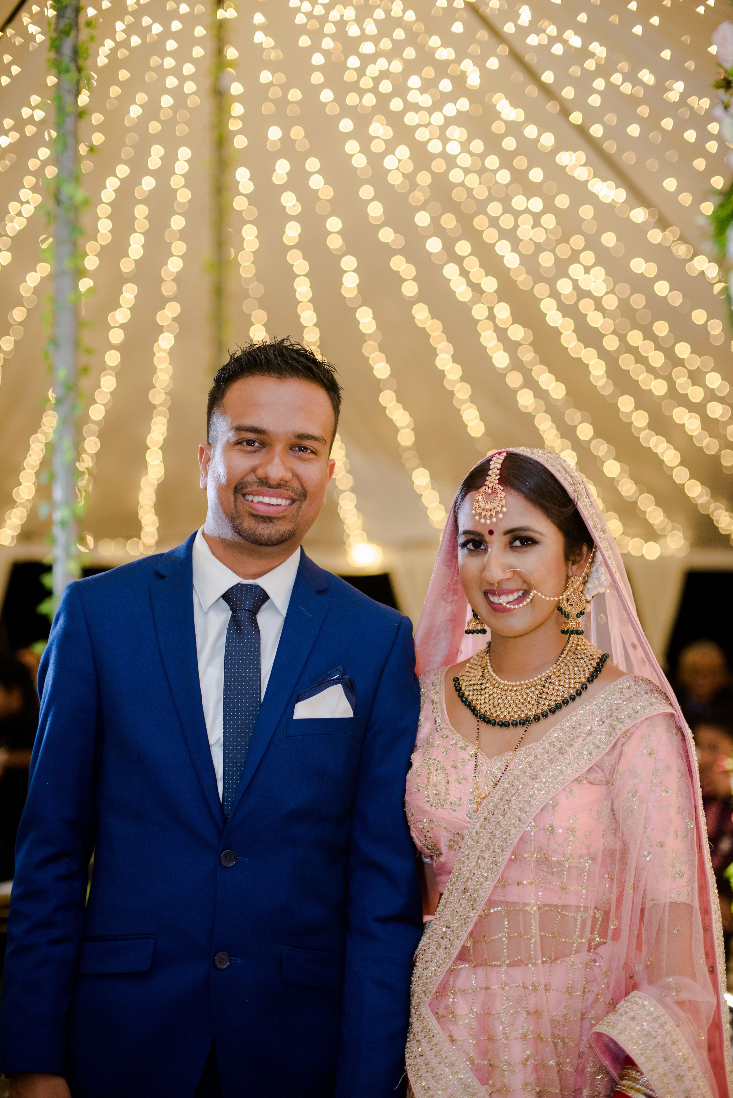 A wedding celebration under a canopy of twinkling string lights creating a magical atmosphere.