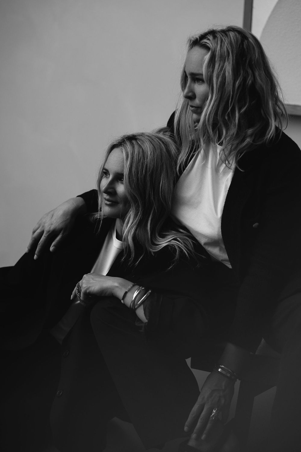 Artistic black and white portrait capturing candid moment between two women.