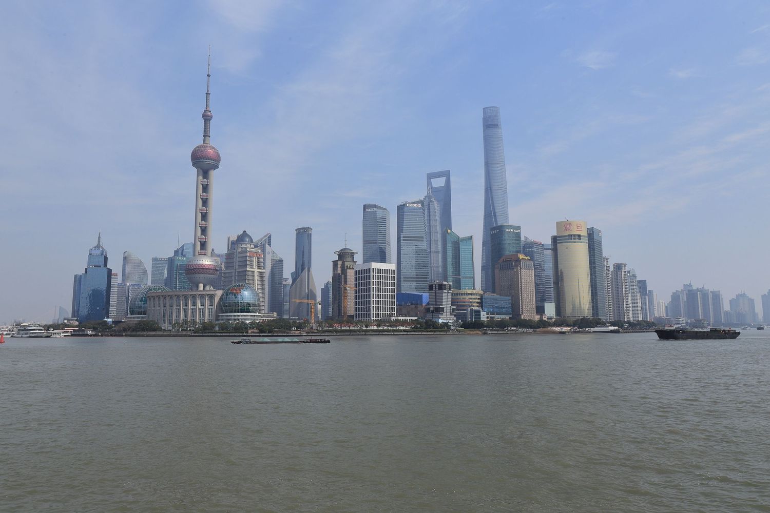 Shanghai skyline with Oriental Pearl Tower and modern skyscrapers along the Huangpu River.
