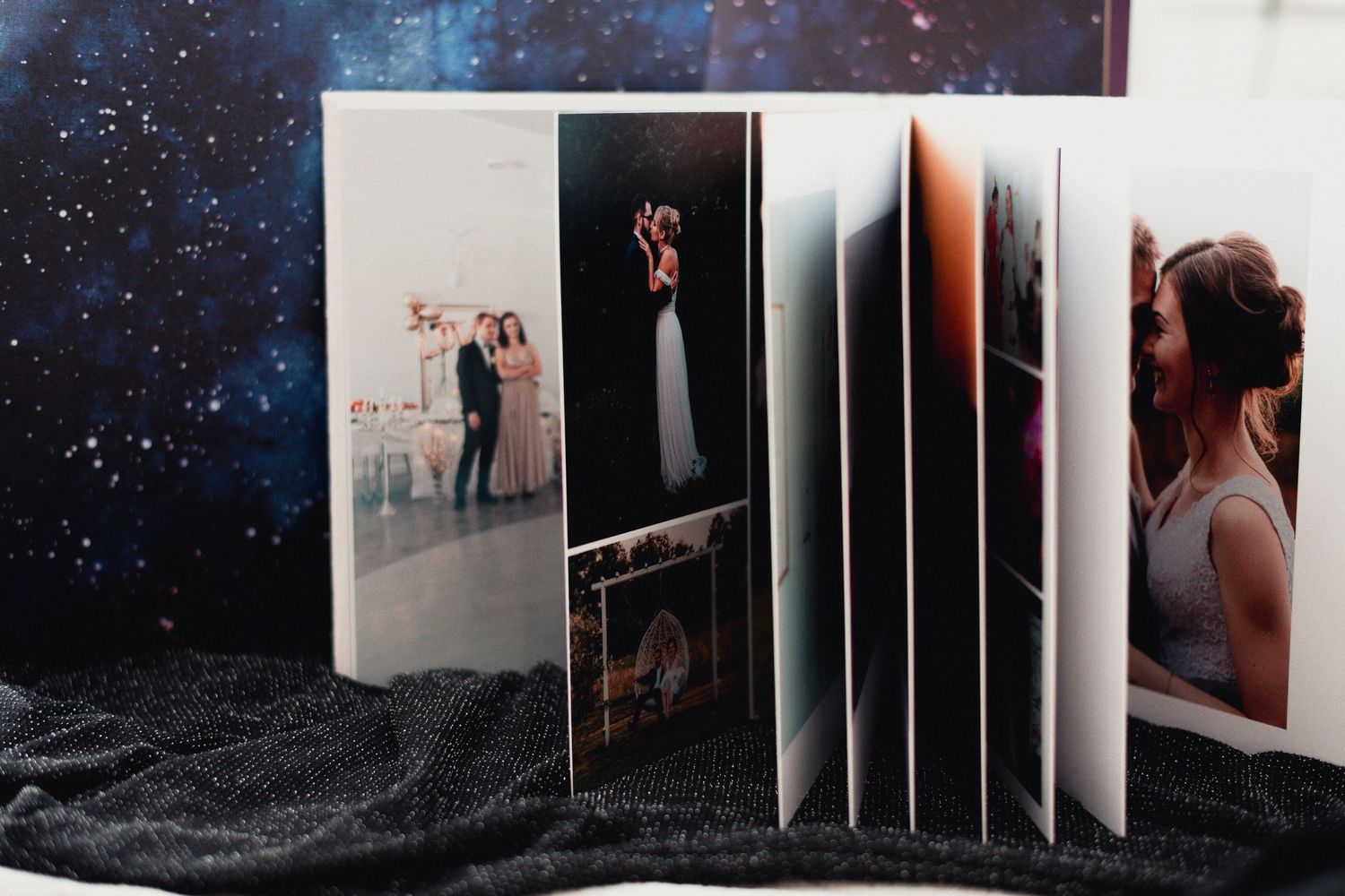 Wedding album spreads featuring starry night sky backgrounds and artistic layouts.