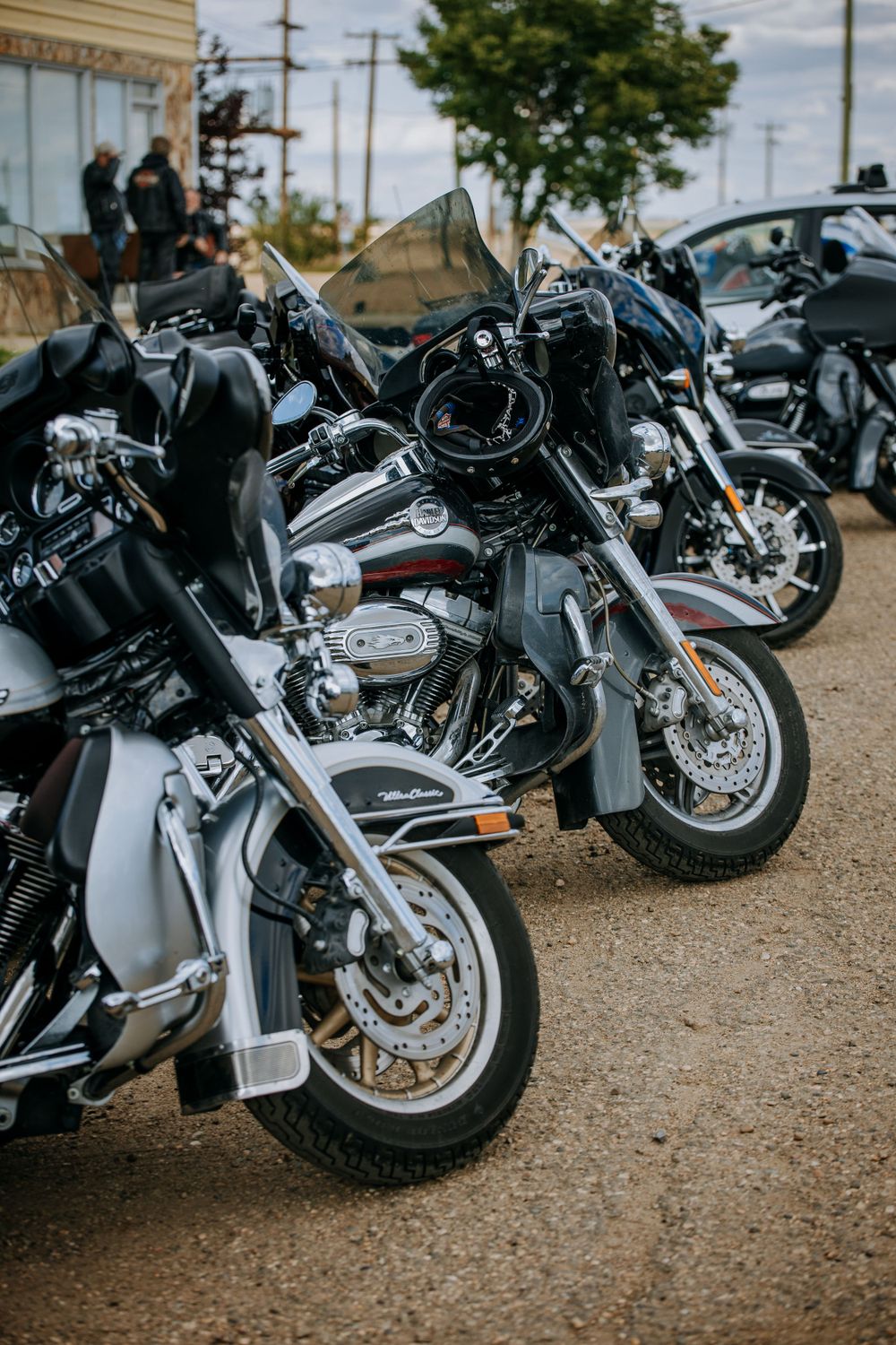 Row of parked motorcycles lined up at outdoor event with chrome details gleaming.