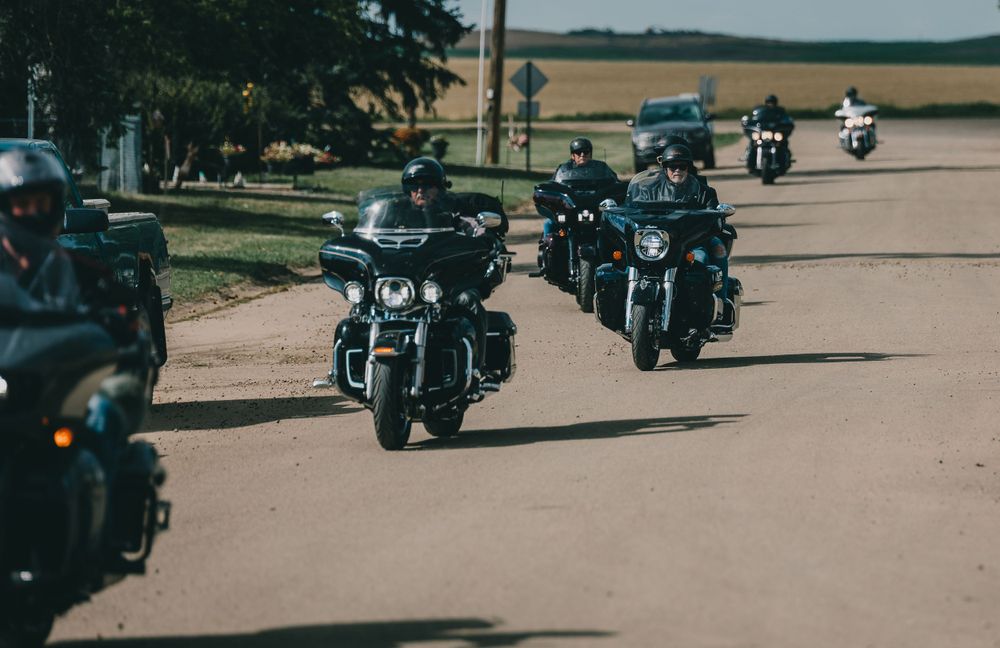 Group of motorcycles riding in formation on an open road.