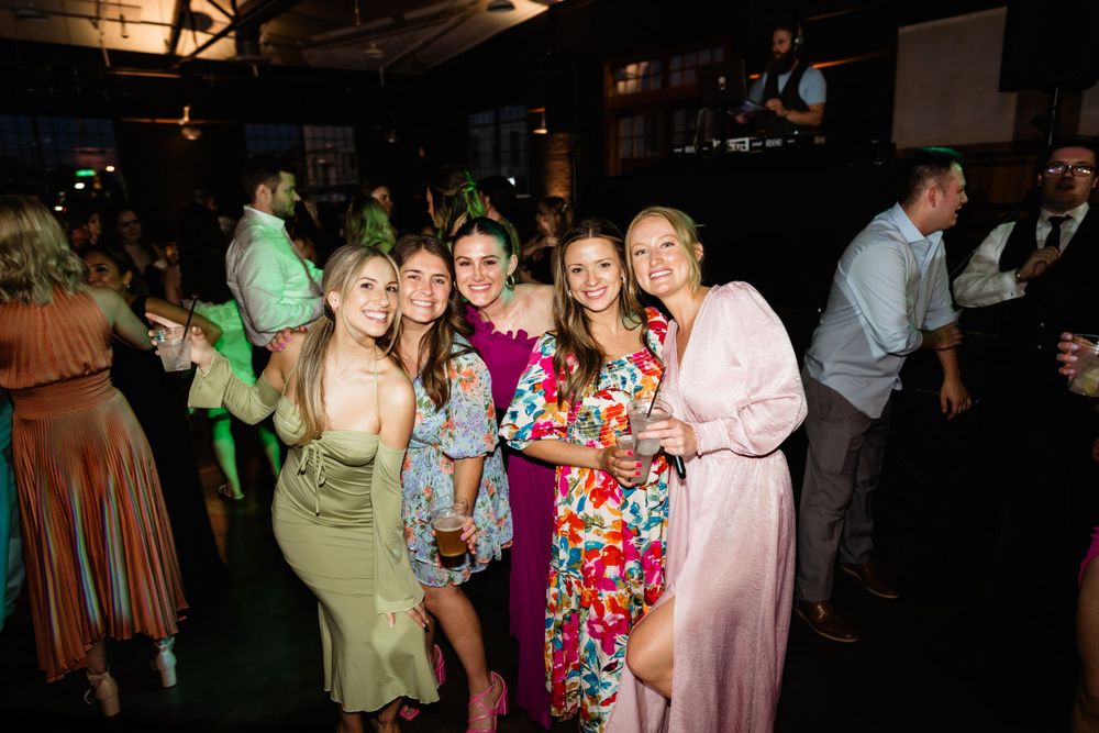 Group of wedding guests in colorful dresses enjoying the reception celebrations.