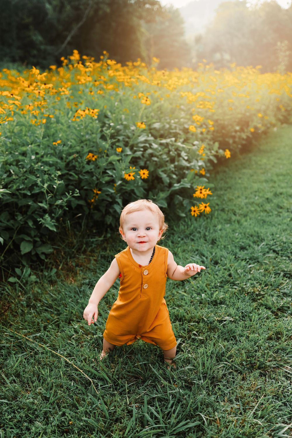 Sweet baby running during an outdoor family session near Oak Ridge, TN beside a field of flowers.