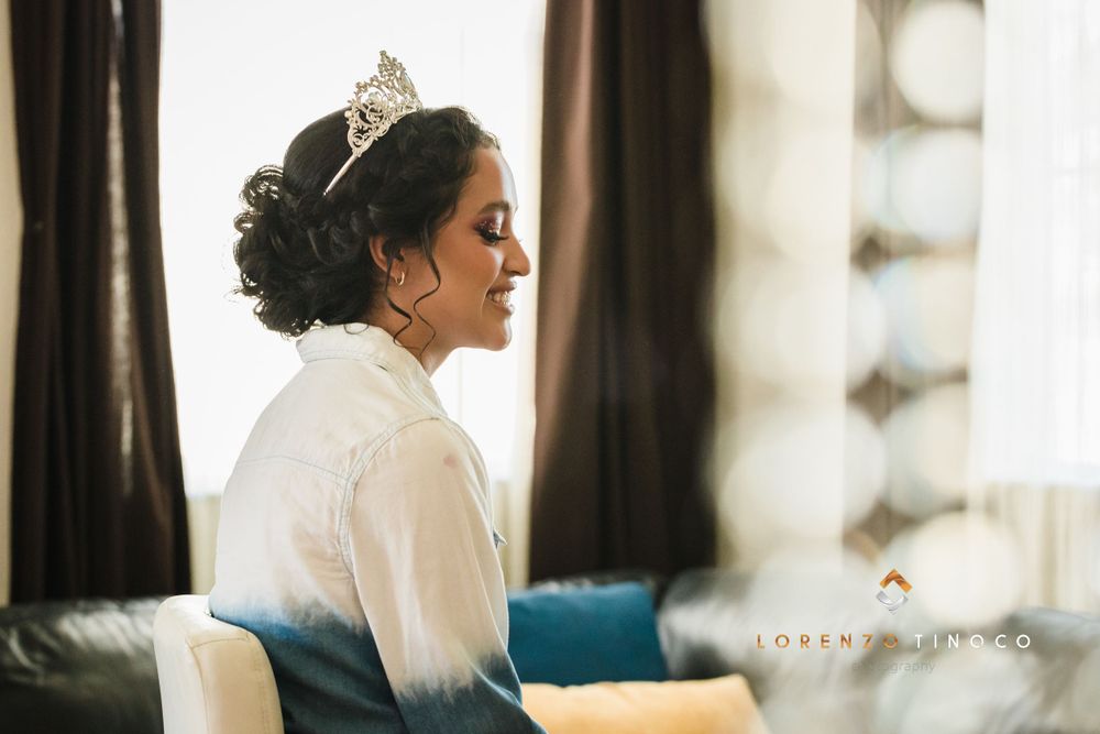 Side profile of elegant updo hairstyle adorned with crystal tiara in natural window light.