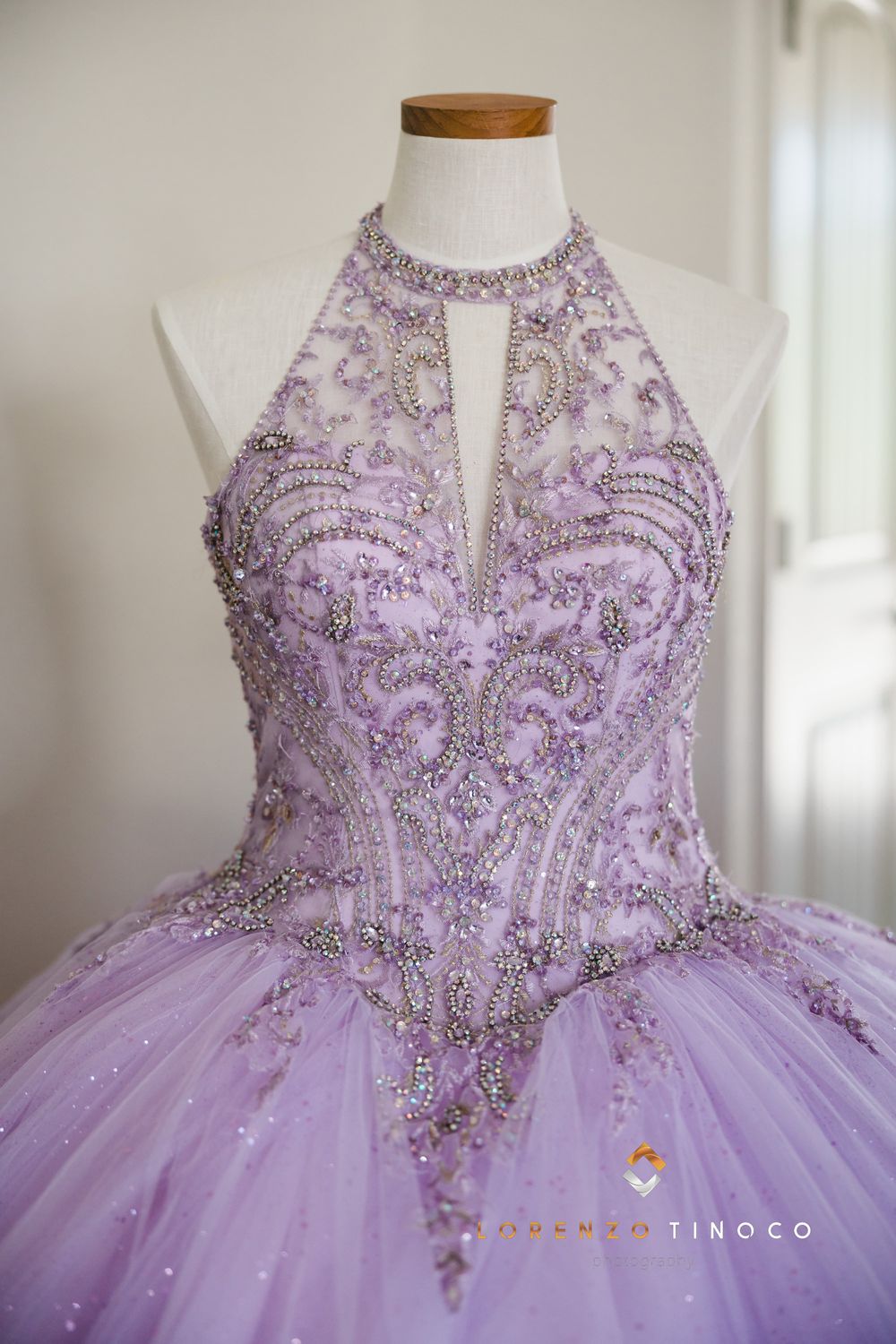 Lavender ball gown with intricate beading and crystal details on mannequin display.