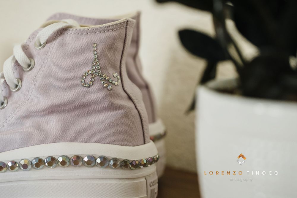 Close-up of pink canvas sneaker decorated with crystal embellishments.