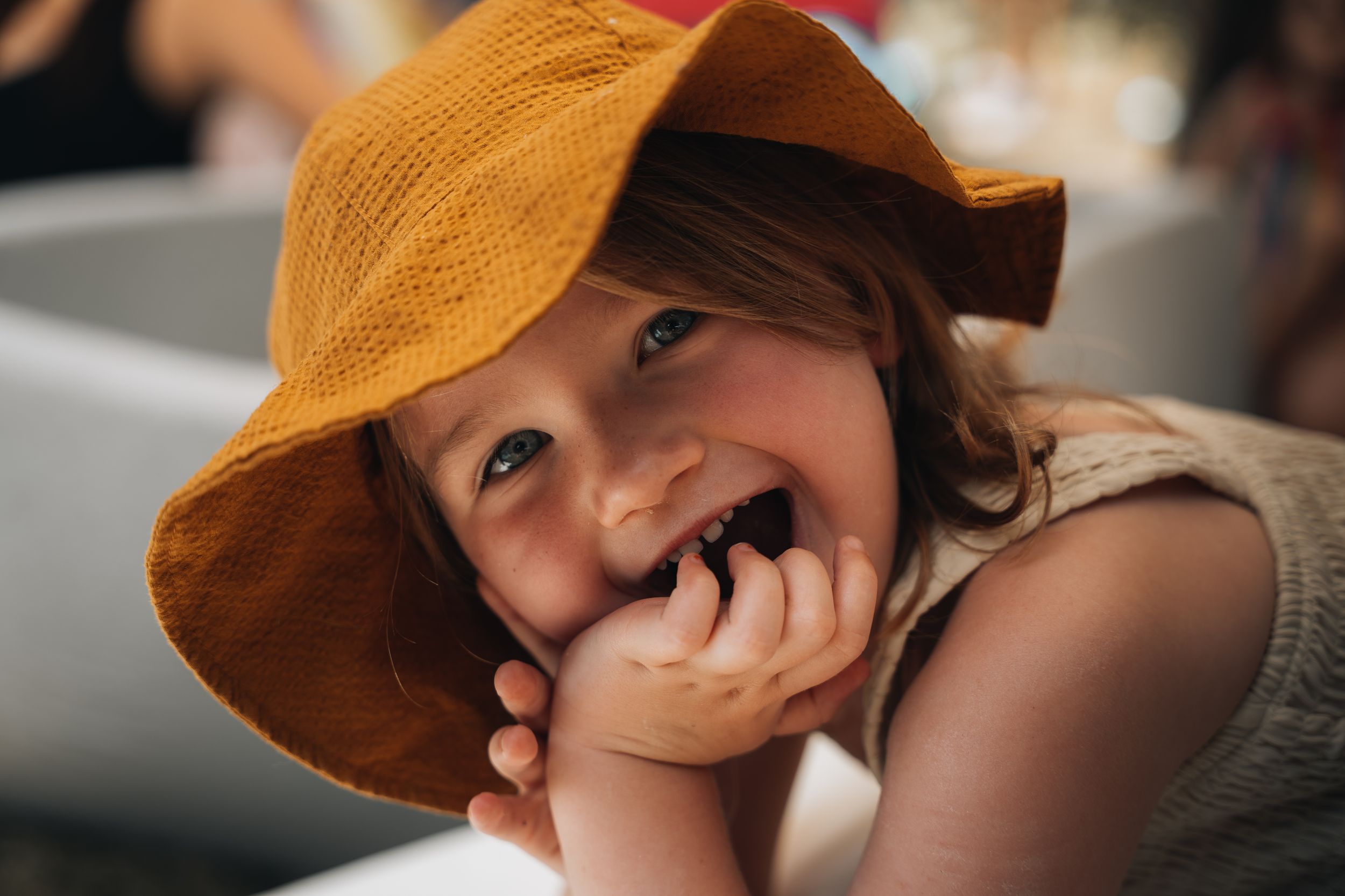 A candid moment captured with a brown sun hat and natural lighting.