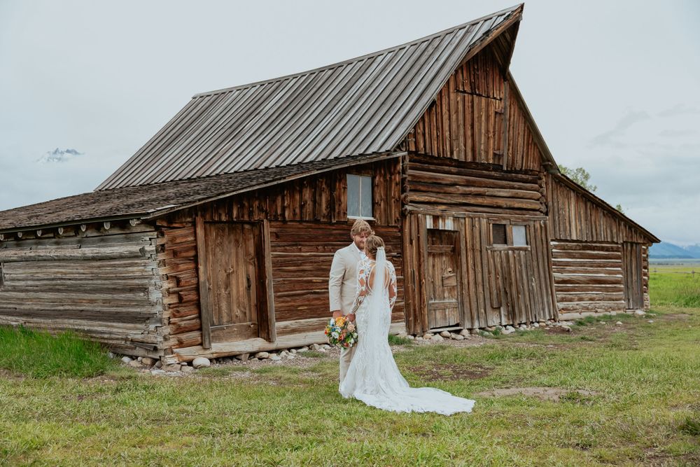 A rustic log cabin wedding venue with wooden architecture and mountain views.