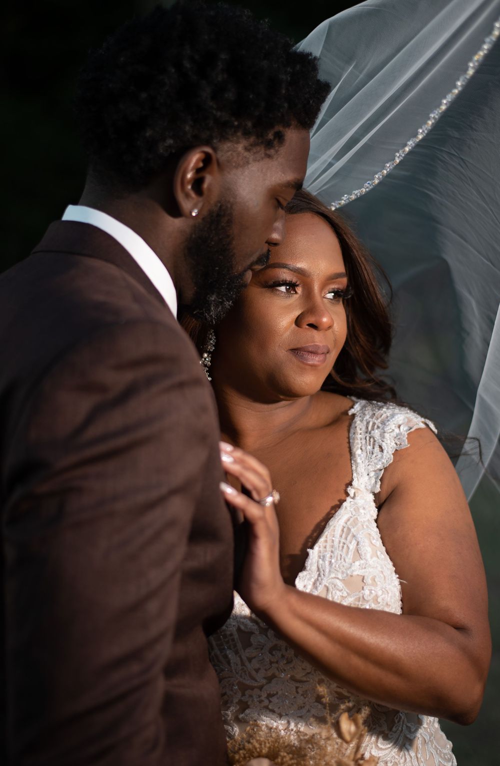 An intimate wedding portrait captured with soft lighting and flowing veil.