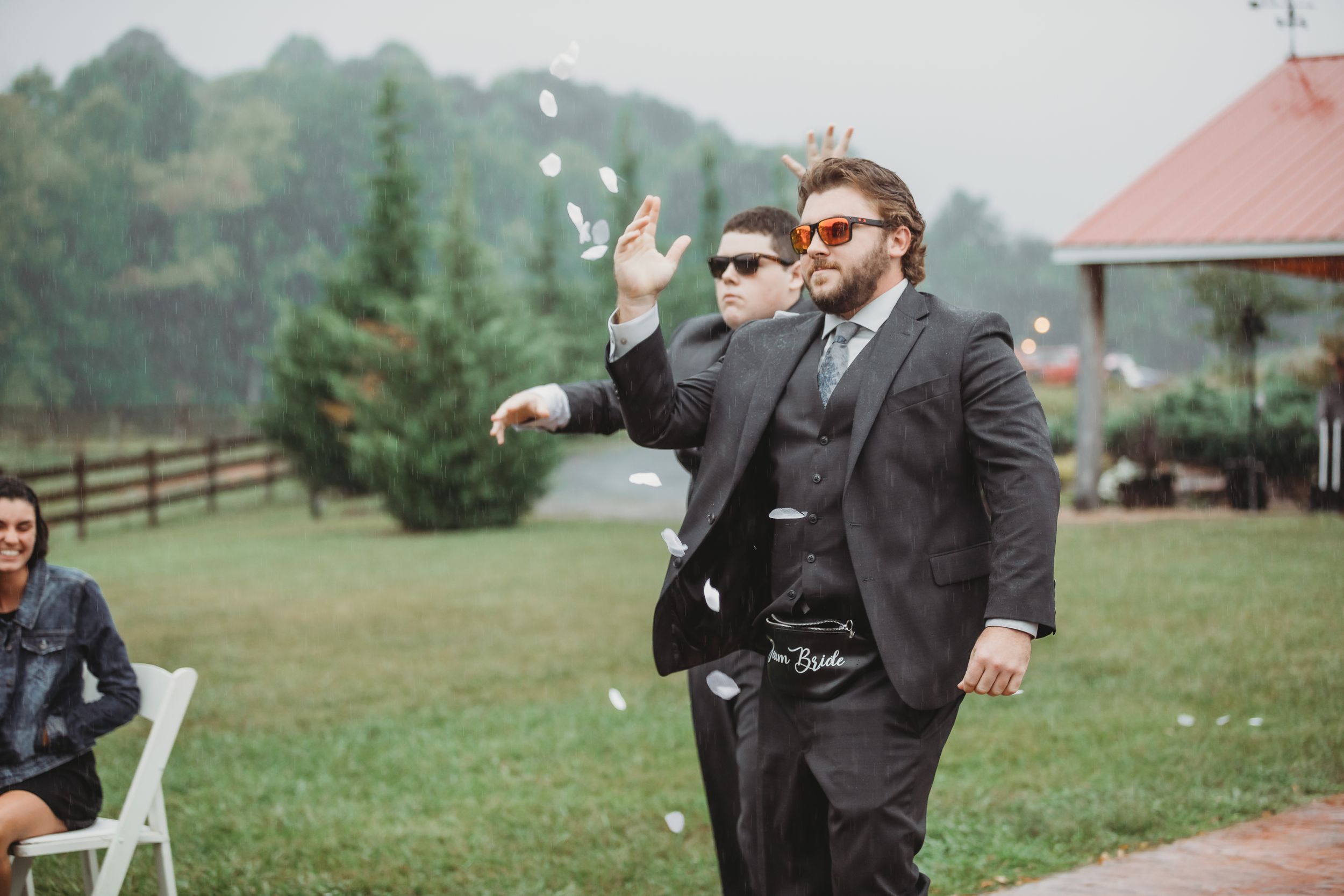 A celebratory moment during an outdoor wedding ceremony with a gazebo in the background.